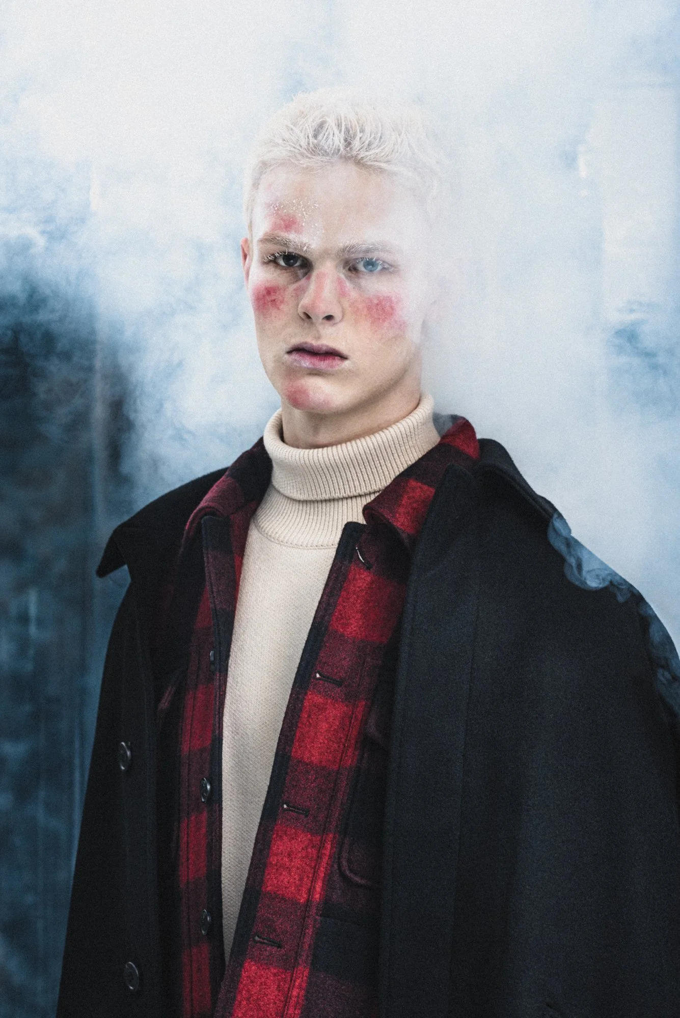 High fashion photograph of a male model surrounded by smoke