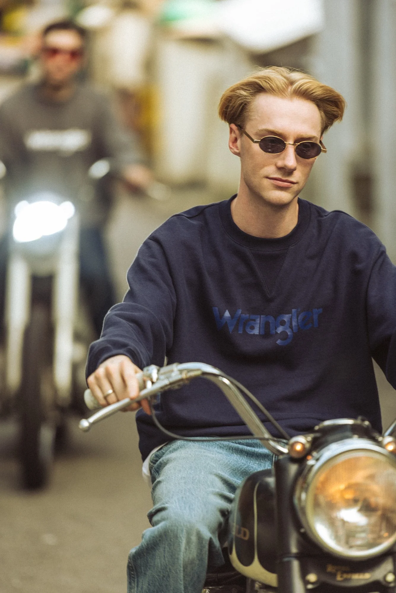 Fashion editorial photograph of male models riding motorbikes and wearing Wrangler