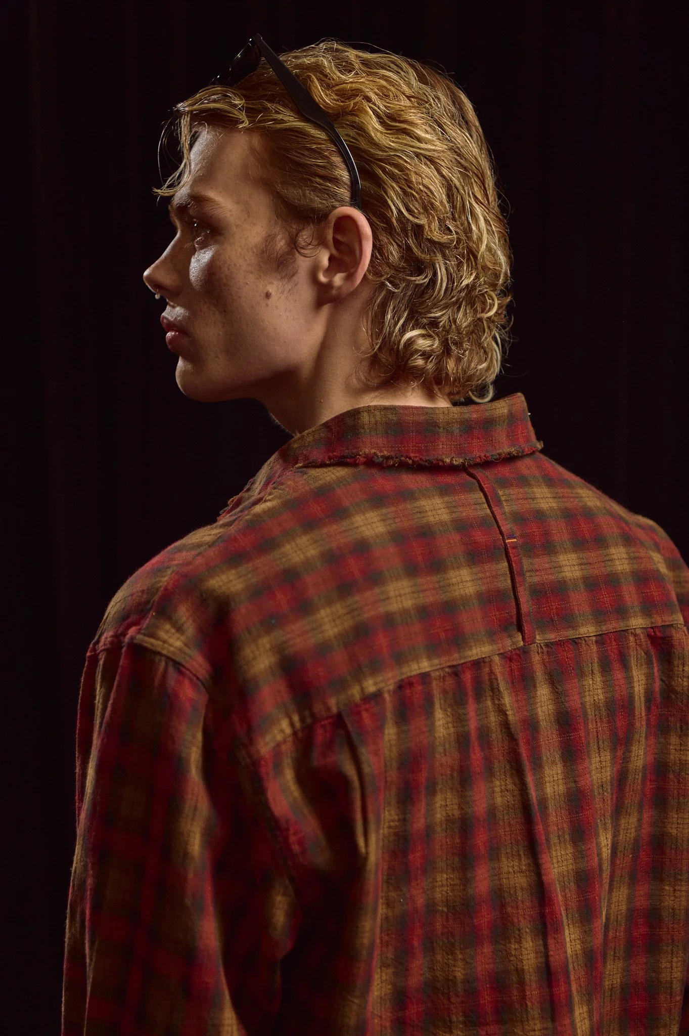 Fashion photograph of a male model against a dark background