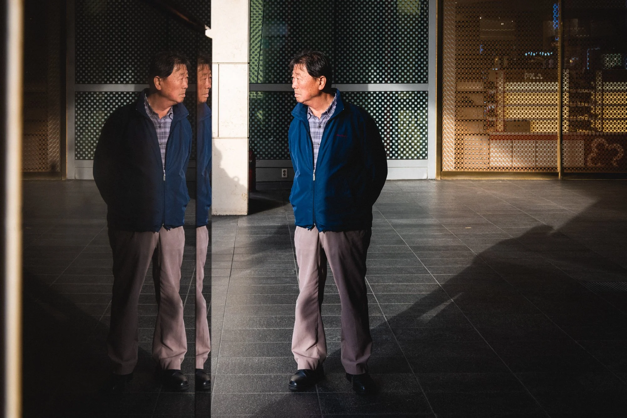 A Korean man and his reflection at Yeongdeungpo Station in Seoul, South Korea