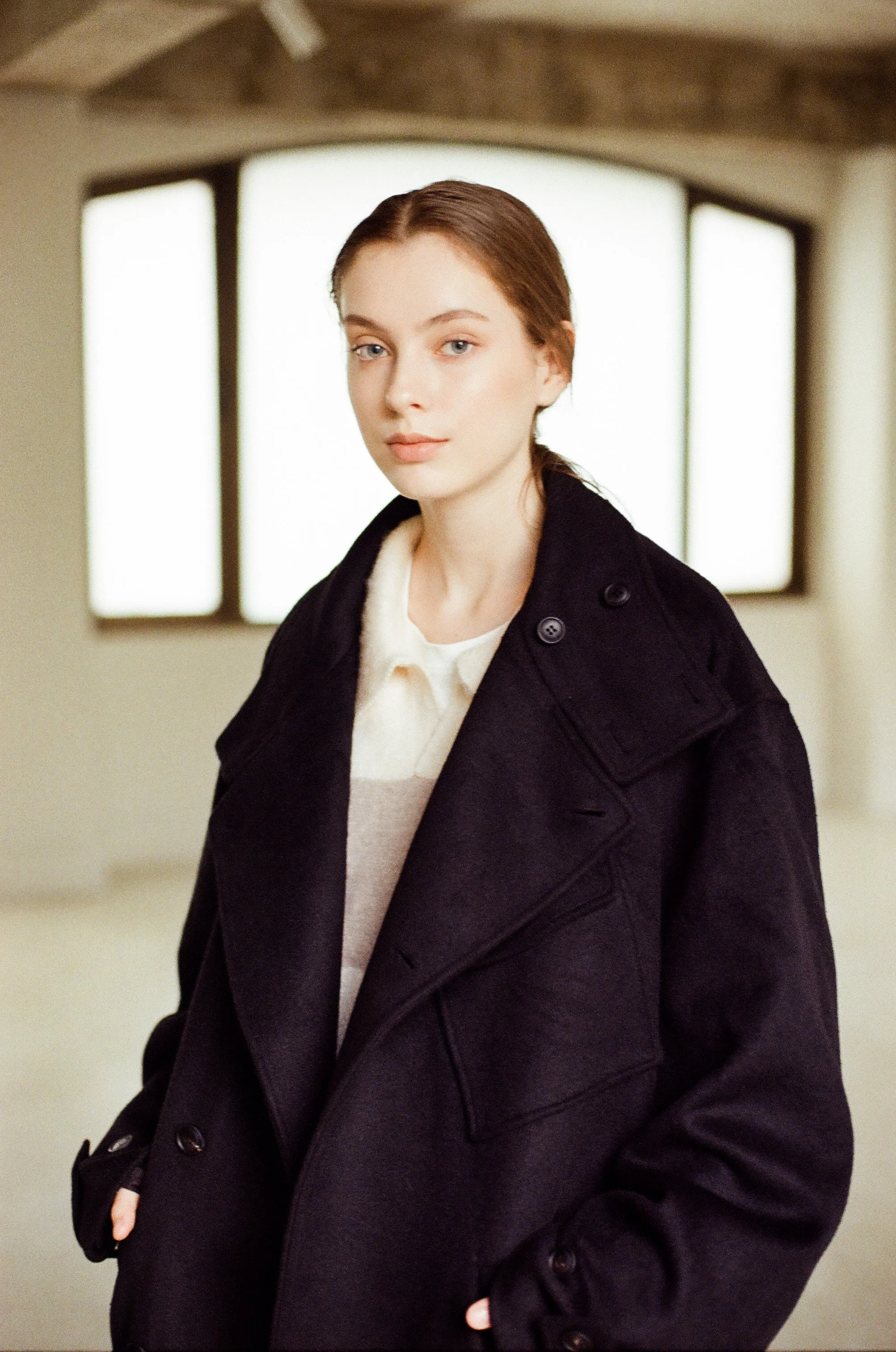 35mm fashion photograph of a female model in an oversized coat