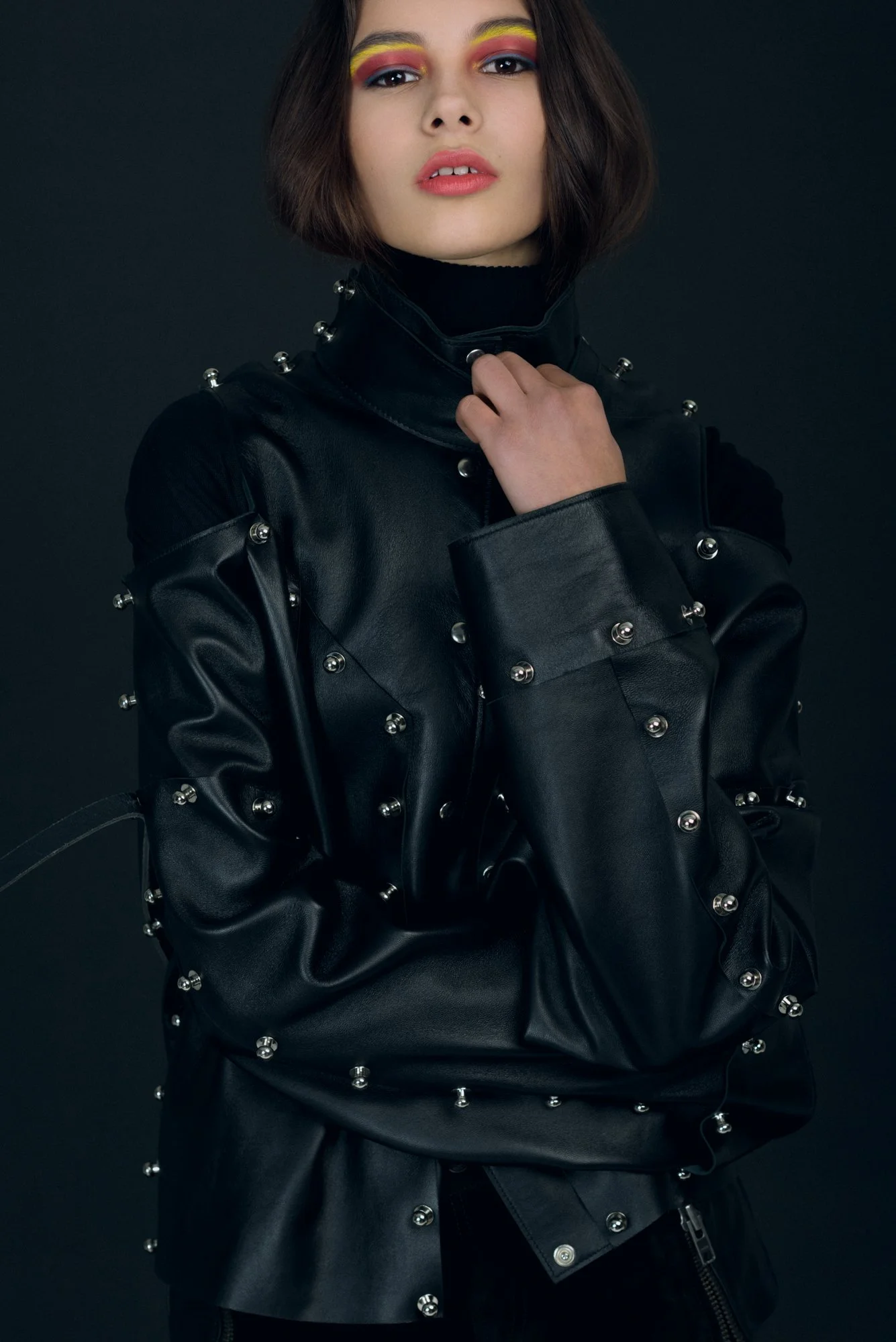 High fashion photograph of a female model in a black leather jacket