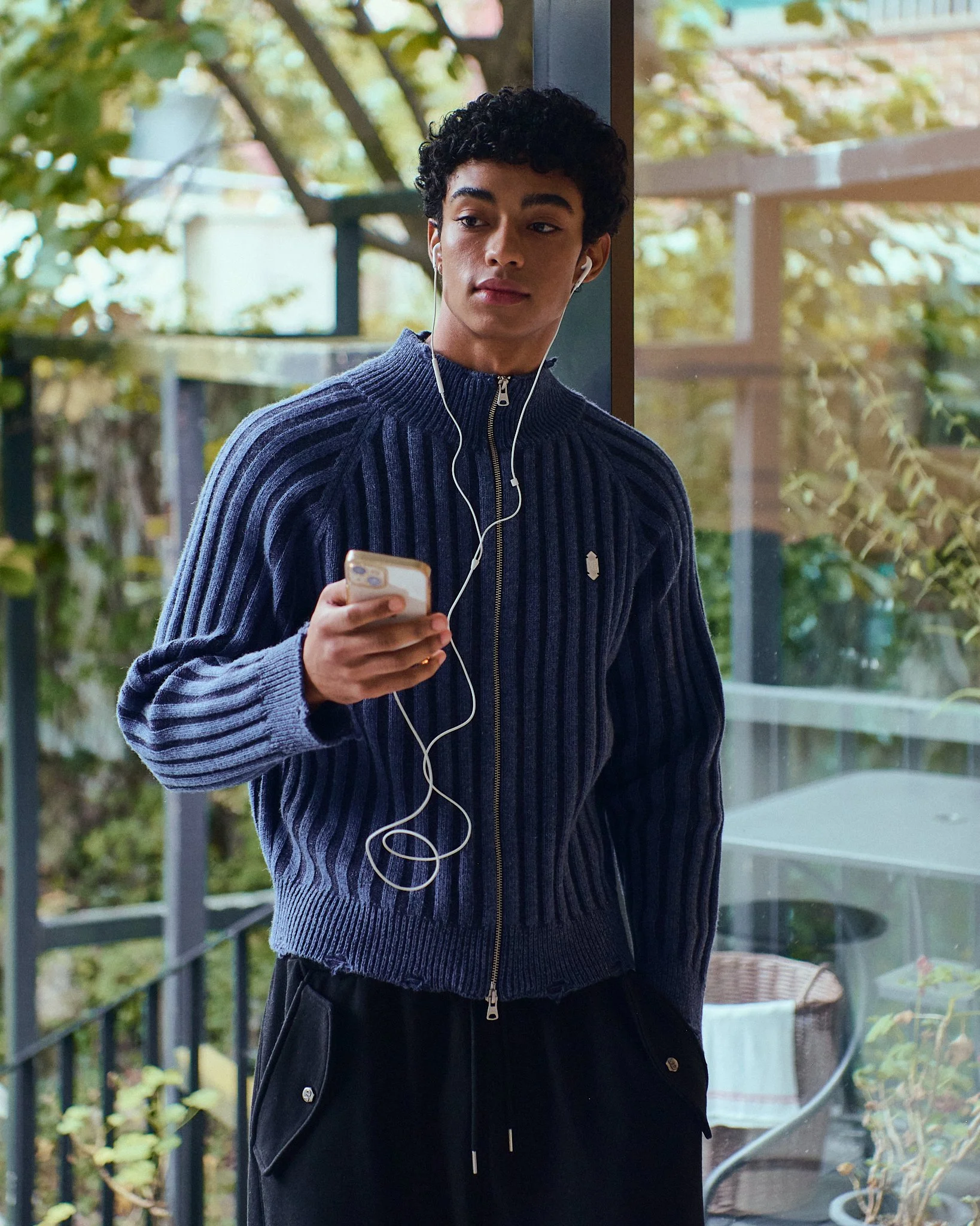 Lookbook photograph of a male model listening to headphones