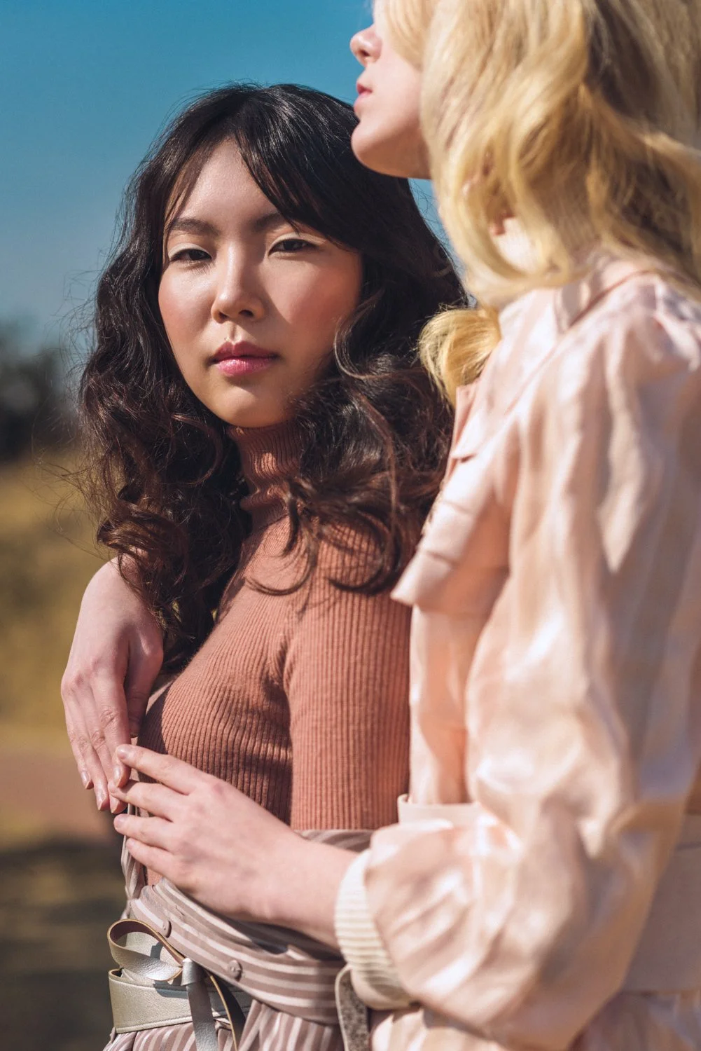 Beauty photograph of a blonde model holding a Korean model