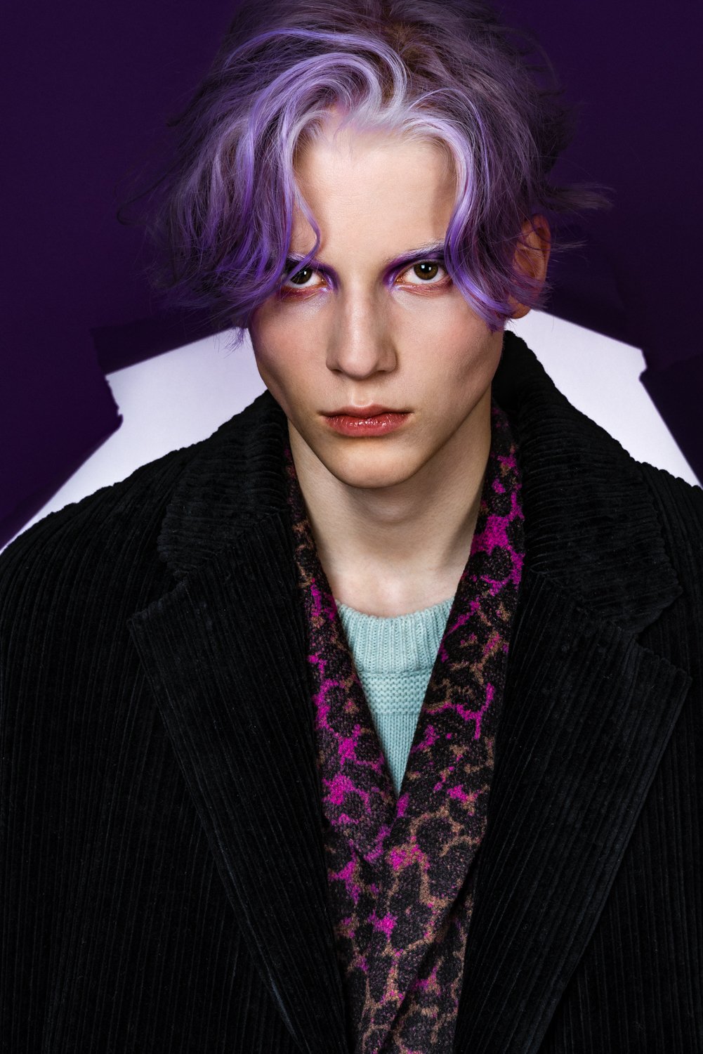 Portrait photograph of a male model with purple hair
