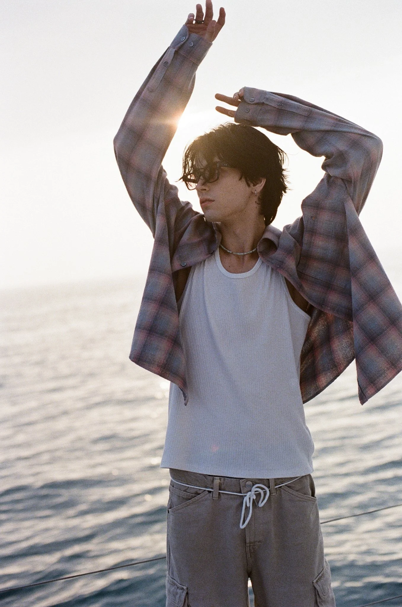 35mm fashion photo of a model by the sea at sunset