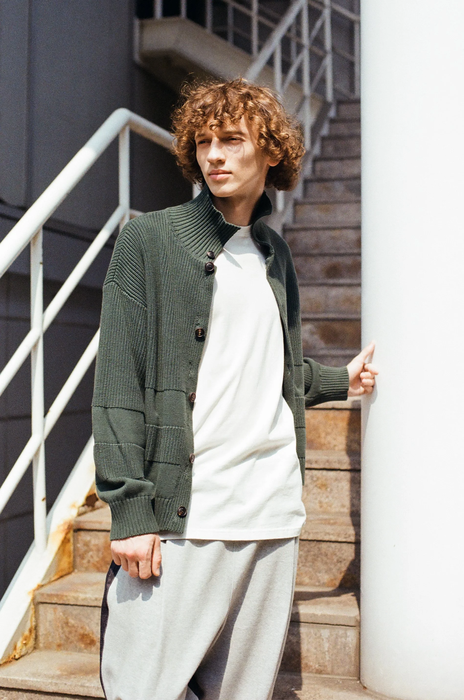35mm film photo of a male model wearing a cardigan