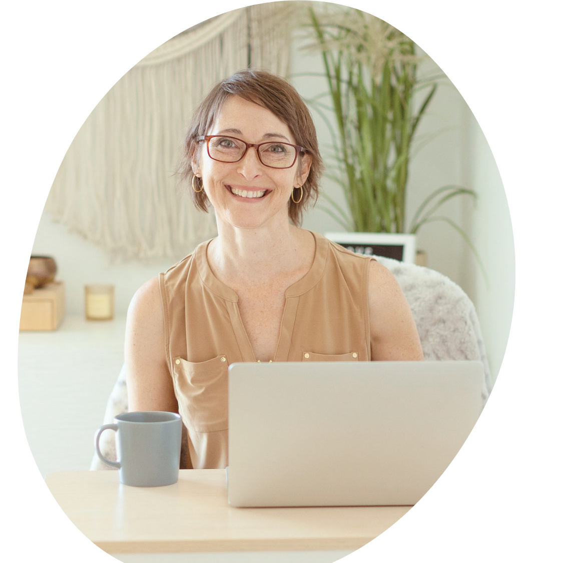 essica Campbell, LPCC, smiling at her laptop in a warm, light-filled office.