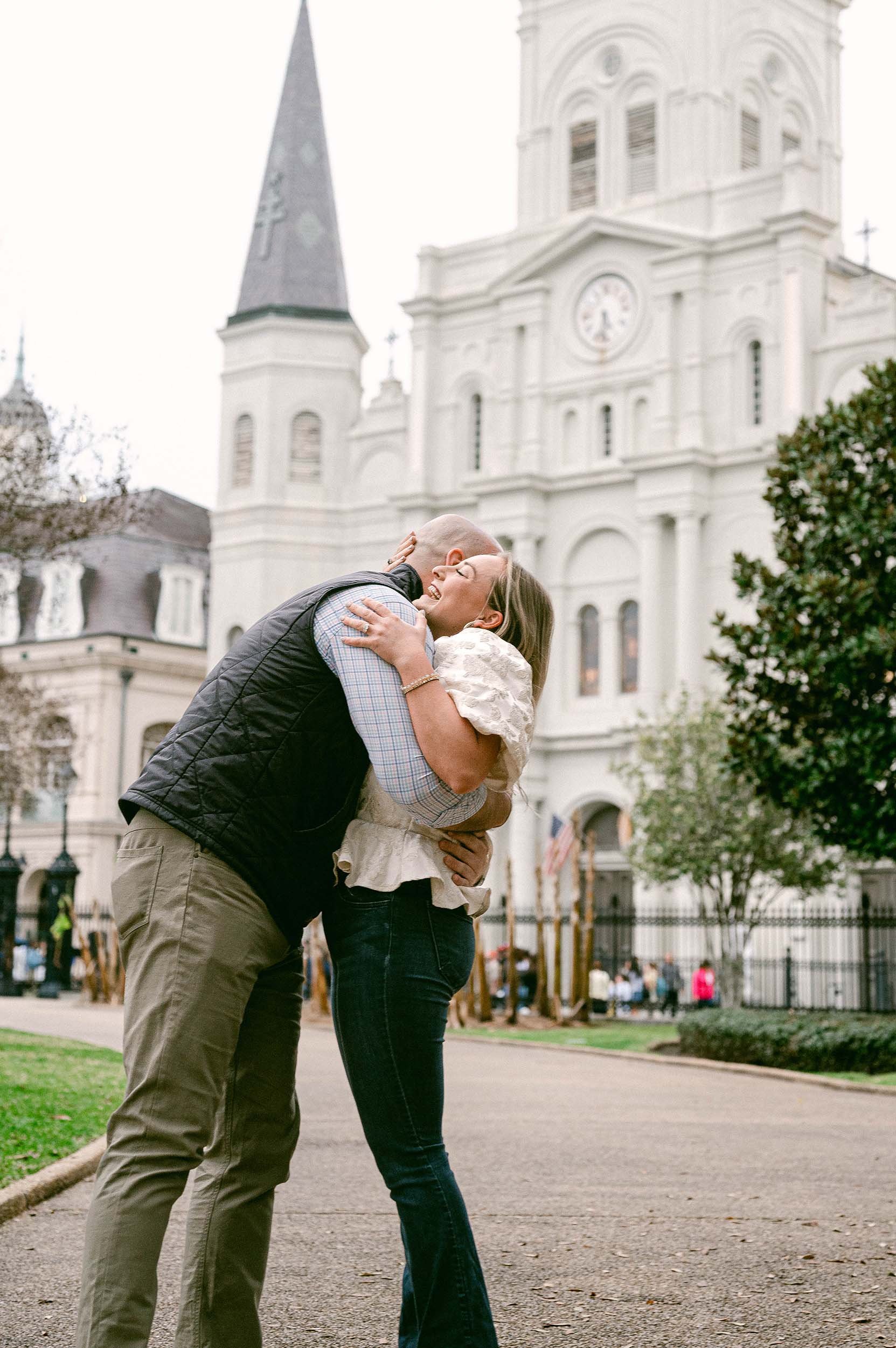 A couple embraces and kisses in front St. Louis Cathedral in New Orleans.