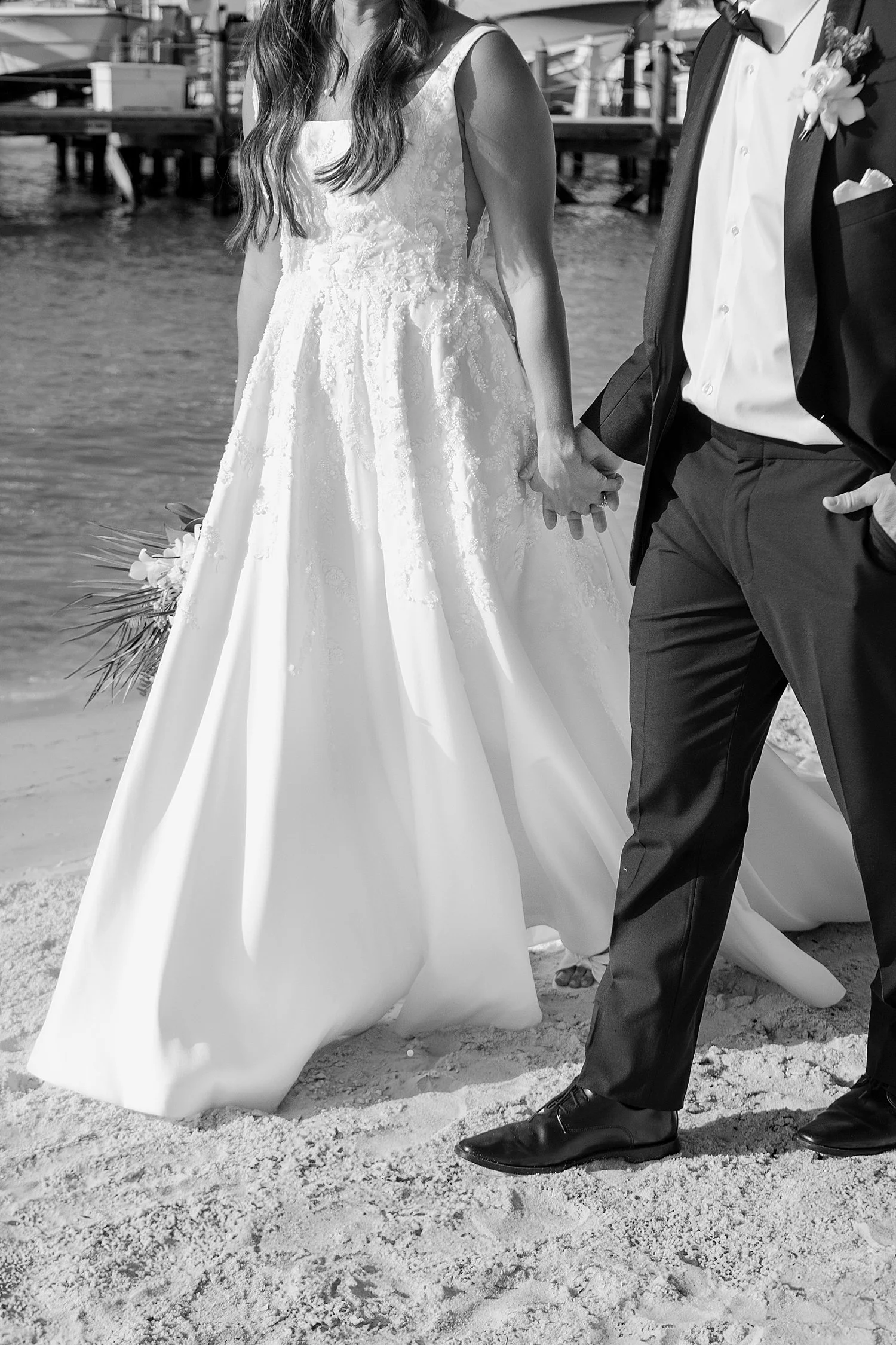 man and woman in formal wear walk hand in hand on the beach by Taylor Shea Photo