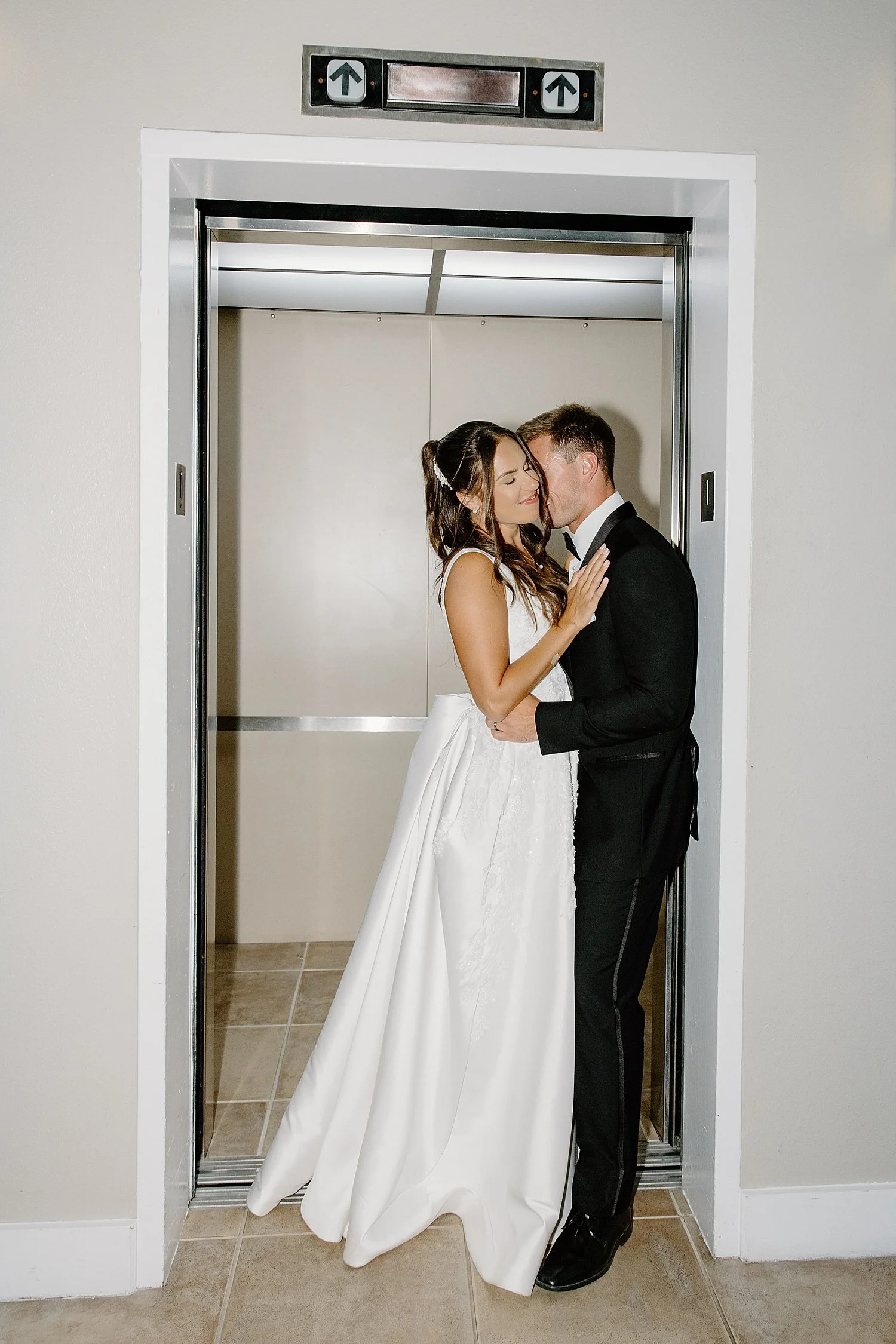 newlyweds pause for a kiss in the elevator at Isla Del Sol Yacht and Country Club