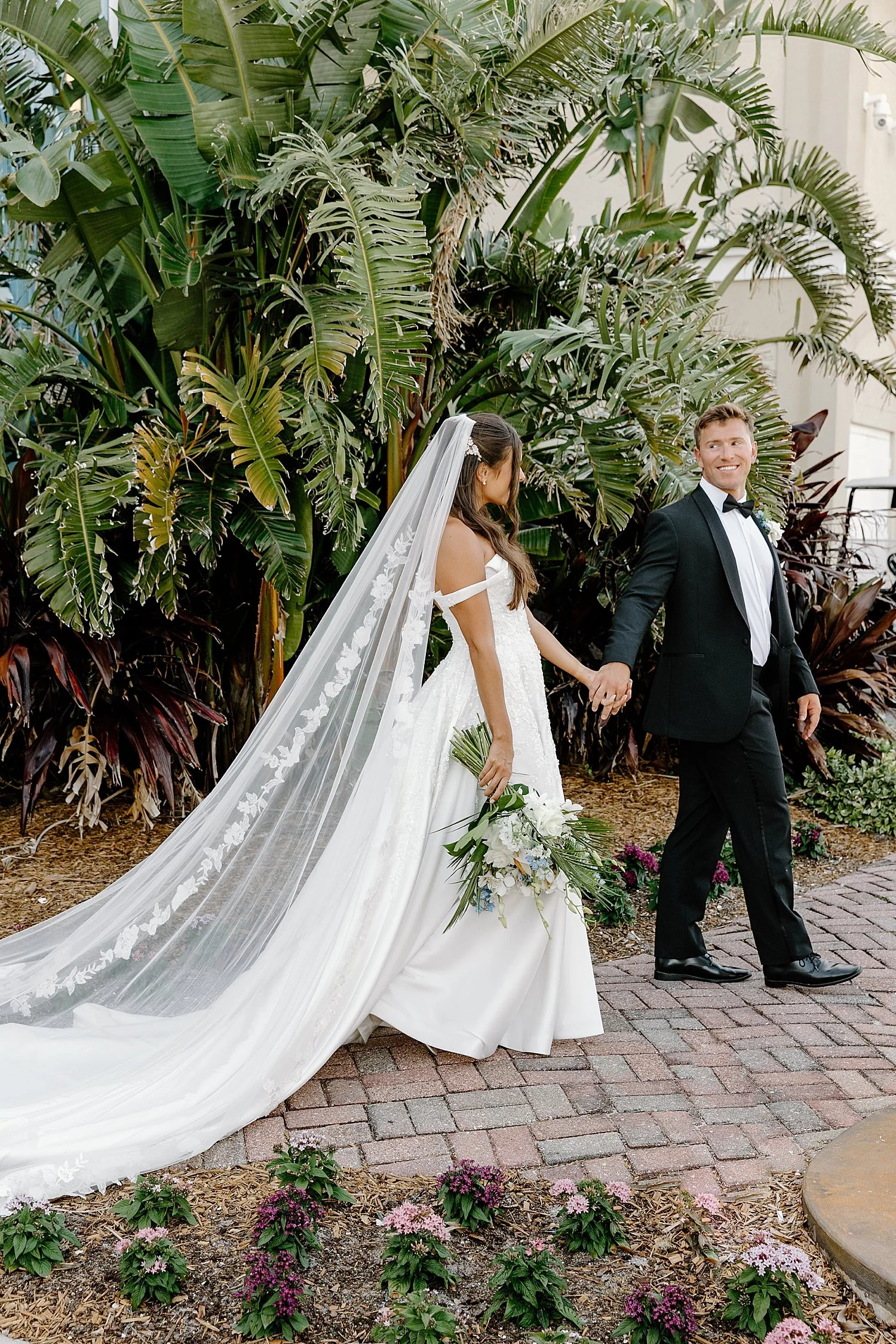 couple walks pathway in front of palm trees by Taylor Shea Photo