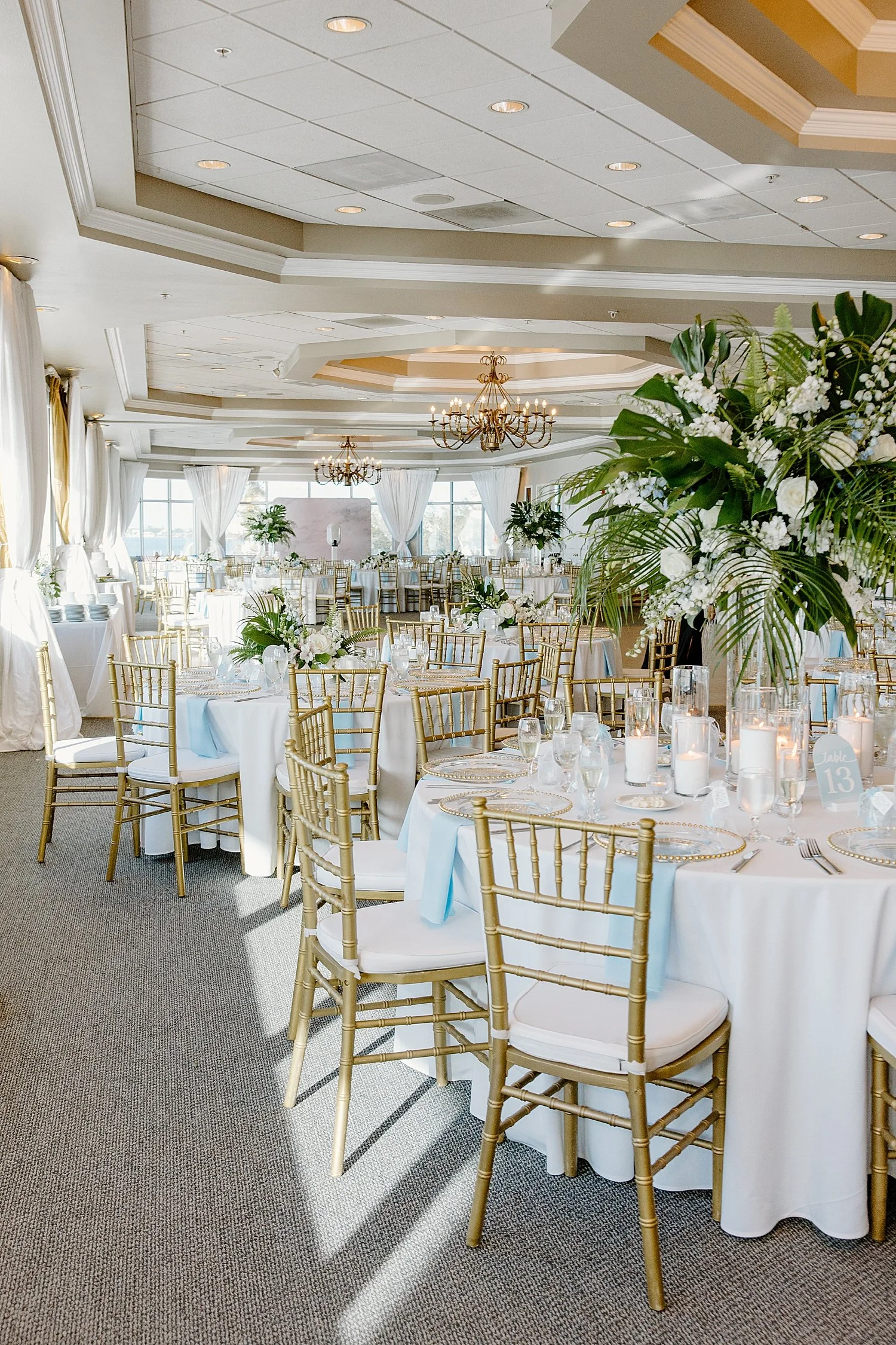 gold back chairs set around white tables with ornate florals by Taylor Shea Photo