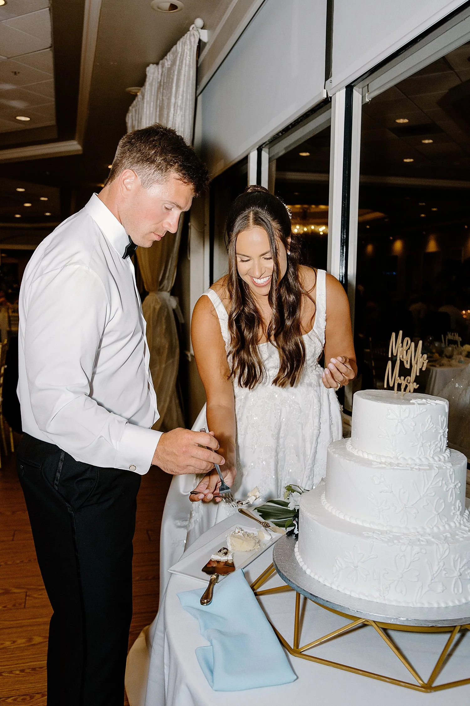 couple cuts their three tiered cake together by Florida Wedding Photographer