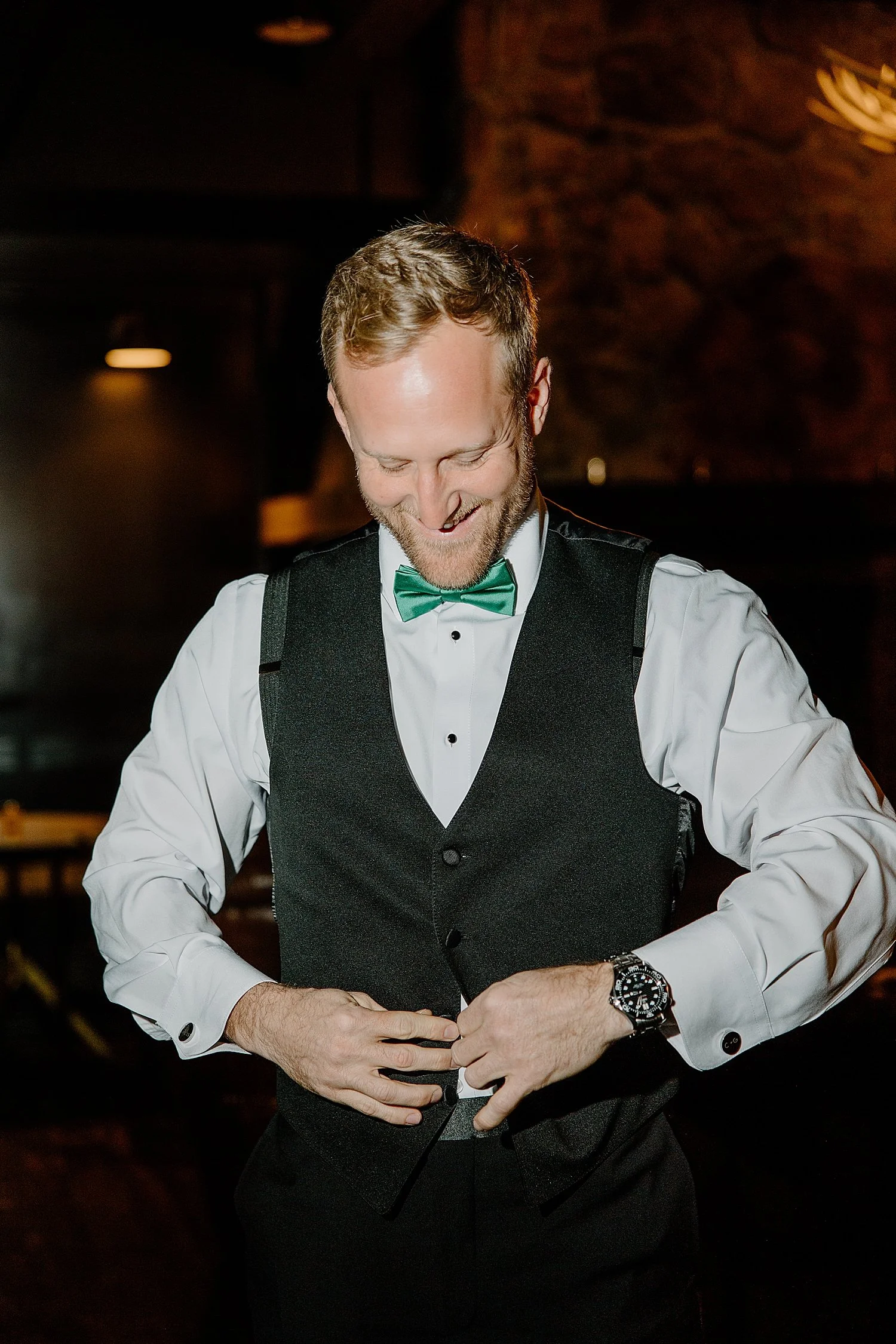  man buttons his vest before his classy &amp; elegant wedding in Florida 