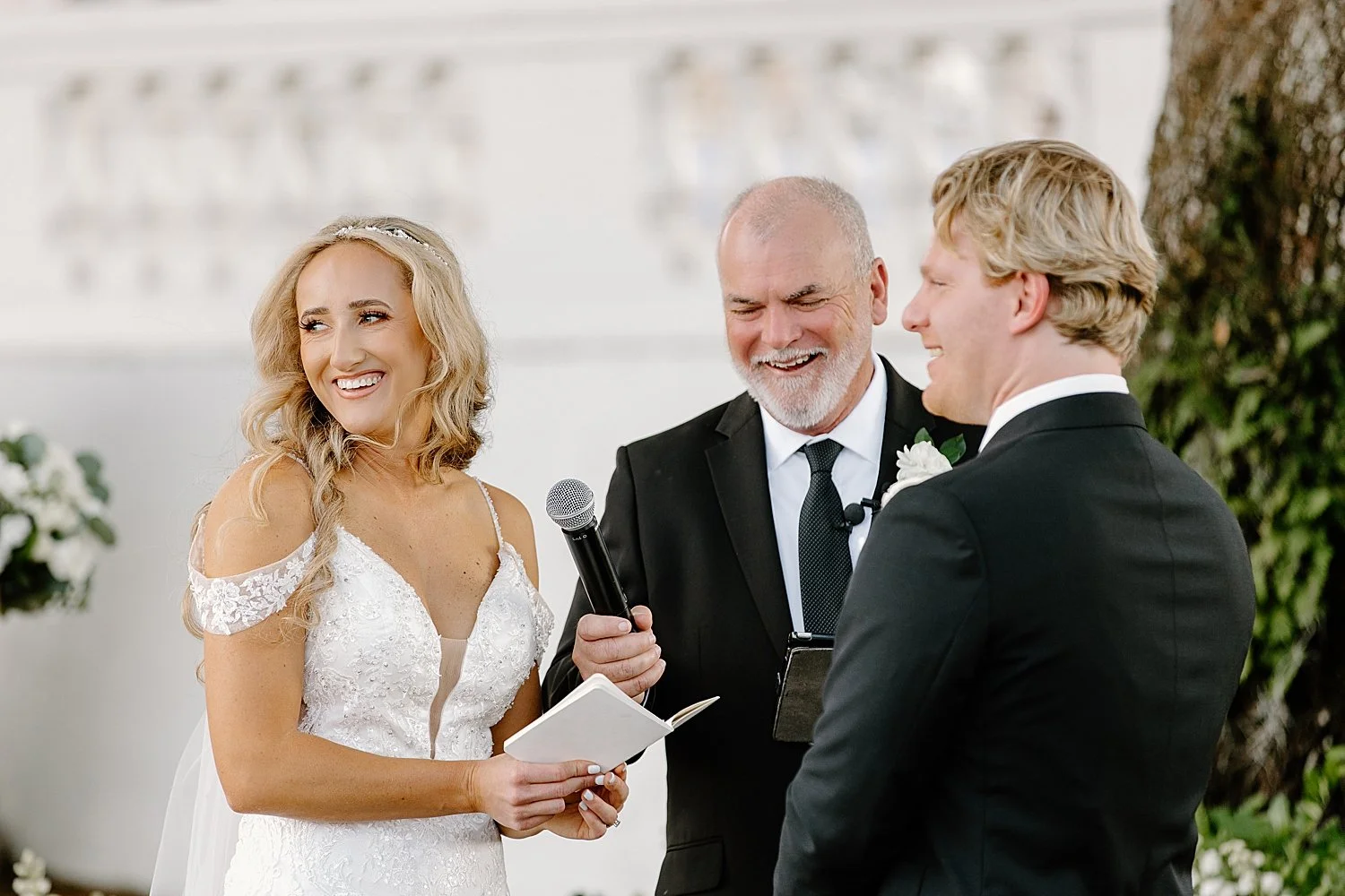  bride looks over her shoulder smiling during outdoor ceremony by Taylor Shea Photo 