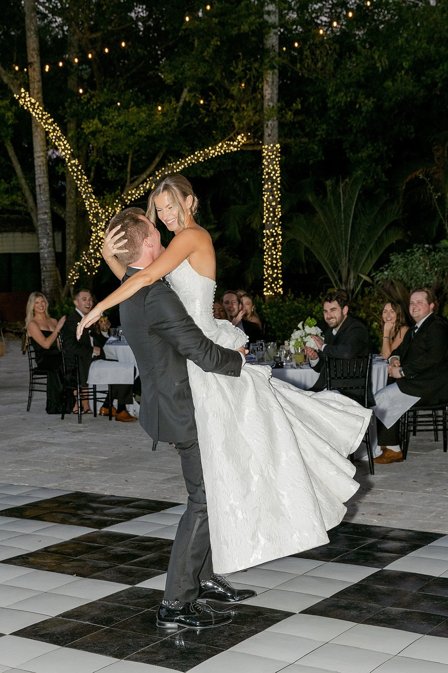  man lifts up new wife on dance floor by Florida wedding photographer 