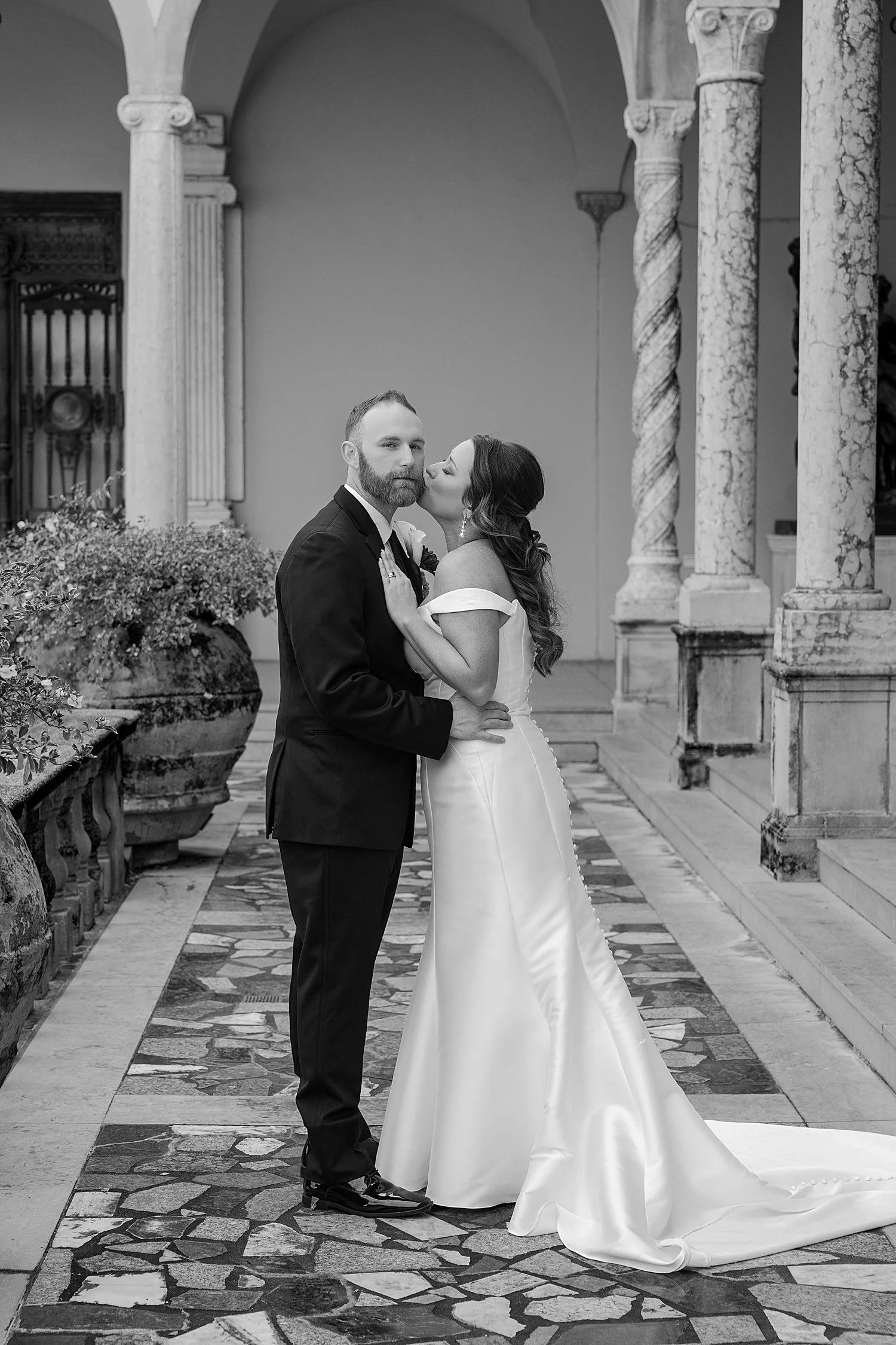  bride leans in to kiss her groom in courtyard by Taylor Shea Photo 