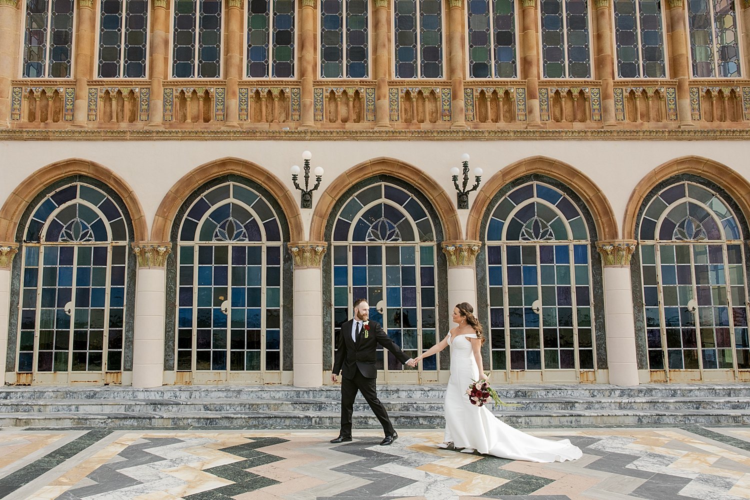  newlyweds walk across courtyard at Ringling Museum before their courthouse elopement 