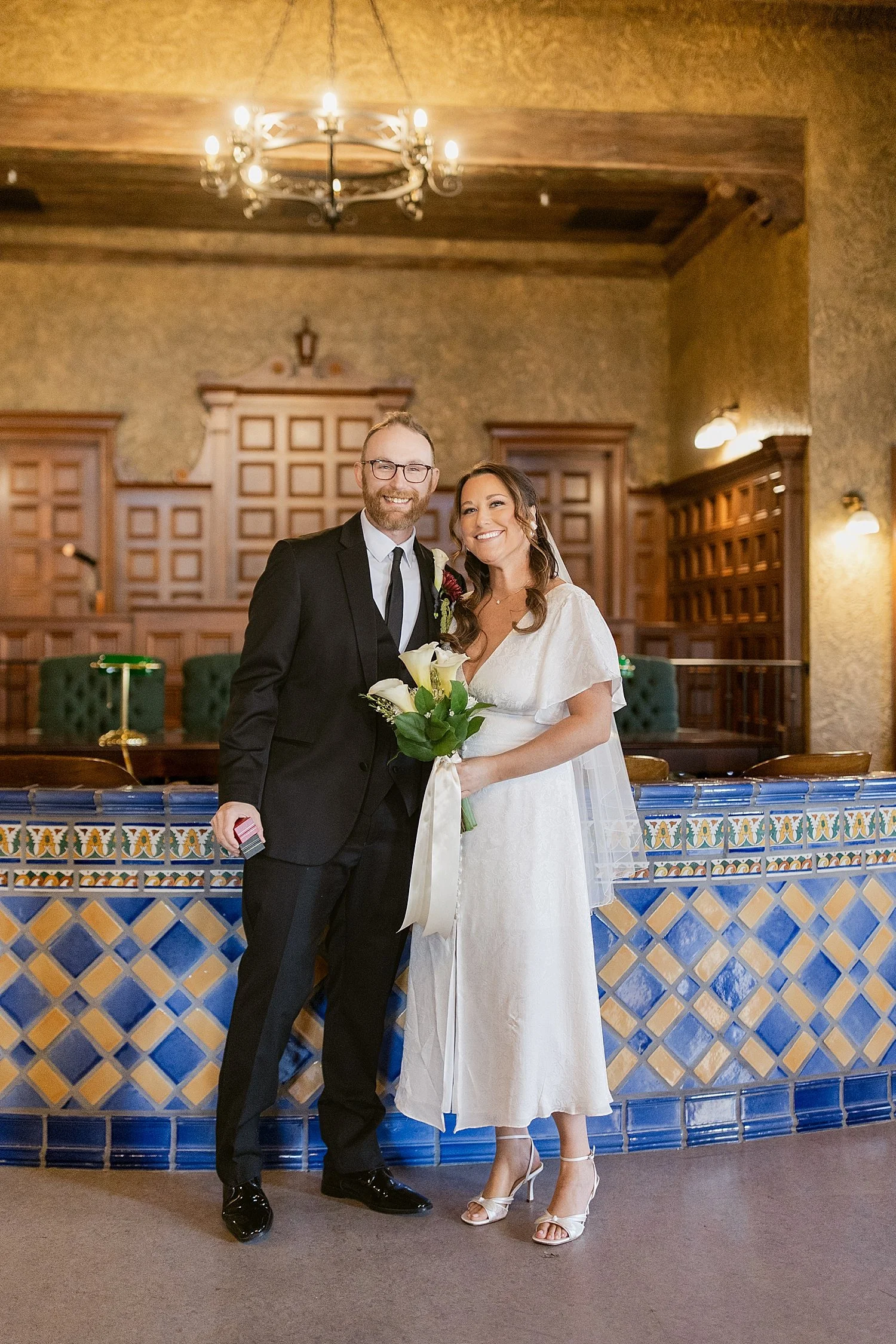  husband and wife kiss in front of blue tile desk in courtroom by Florida wedding photographer 