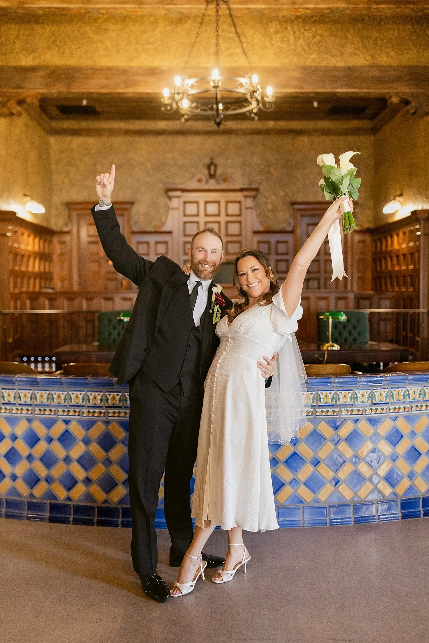  newlyweds throw their hands in the air in celebration in a courtroom by Florida wedding photographer 