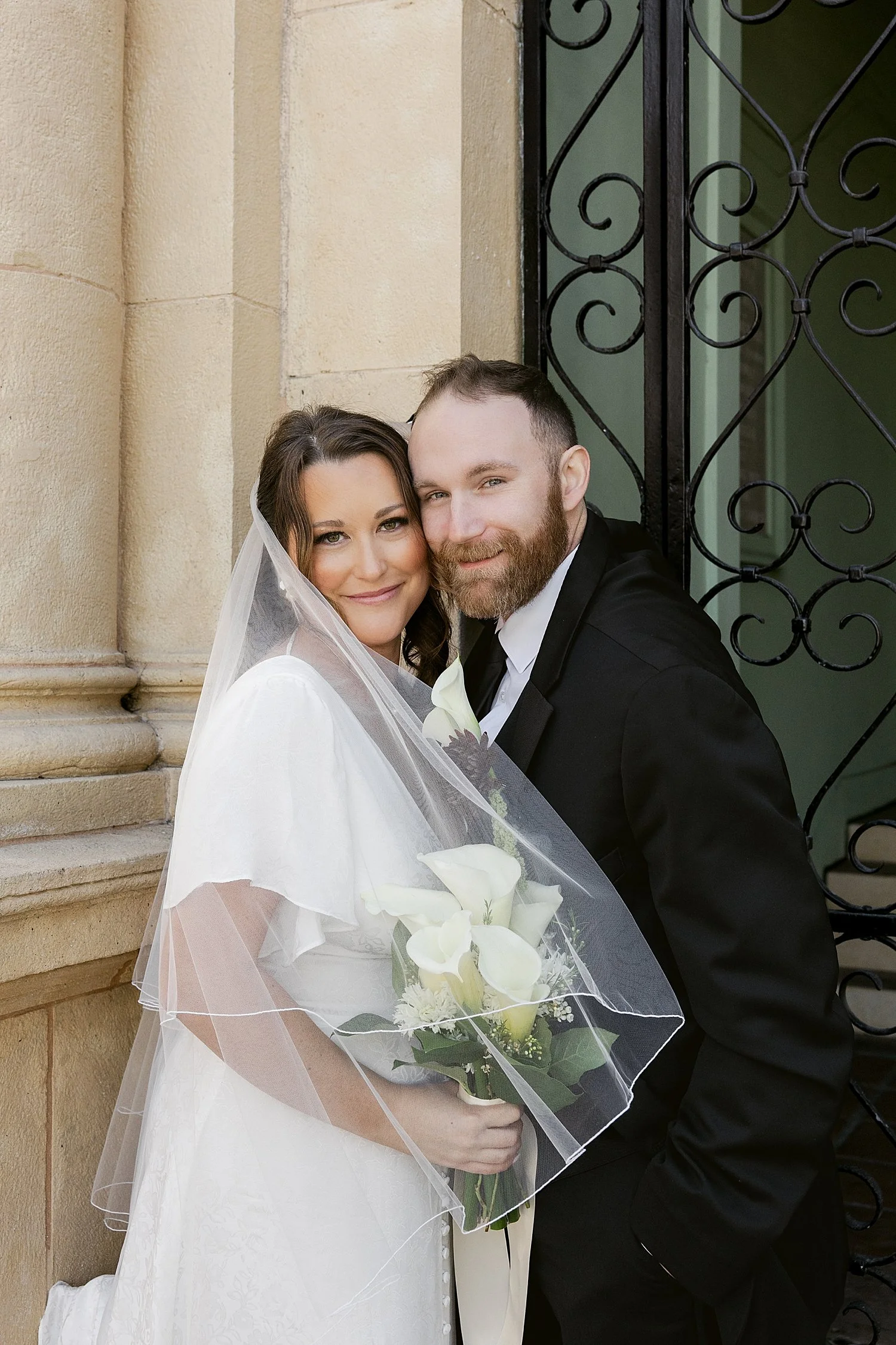  newly married couple grin together on historic building steps by Taylor Shea Photo 