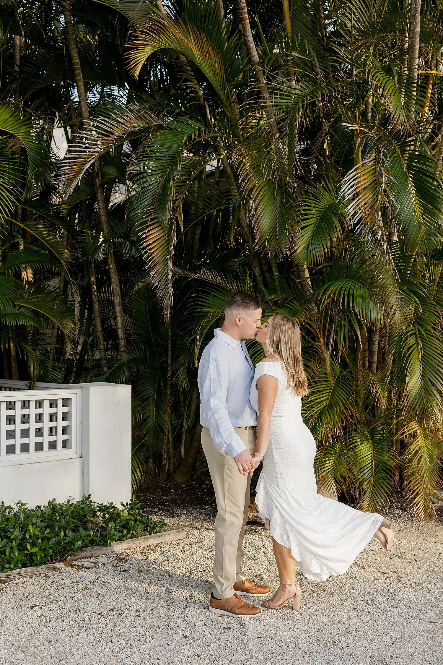  bride to be kisses her groom by lush tropical trees on Boca Grande Island 