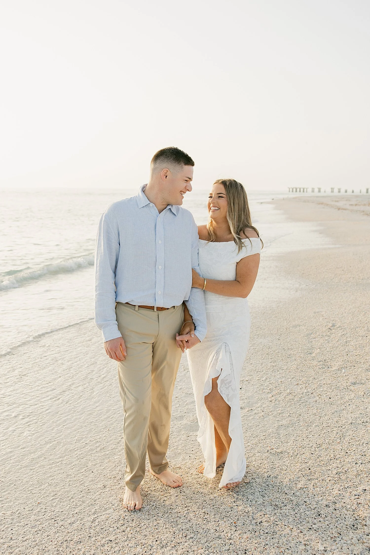  man and woman snuggle together in the fading evening light near the water by Taylor Shea Photo 
