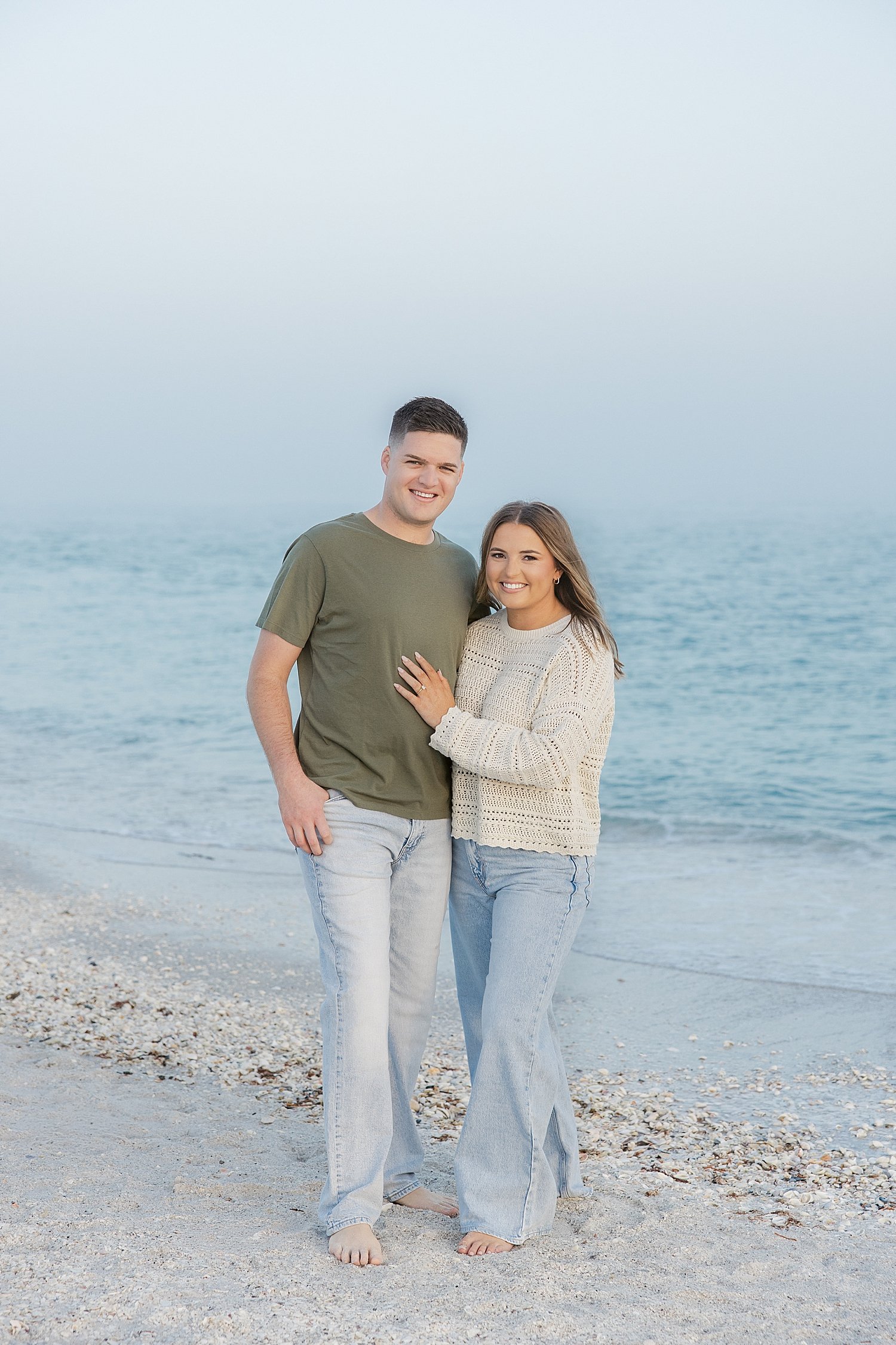  groom in green shirt and his fiance stand on beach by Taylor Shea Photo 