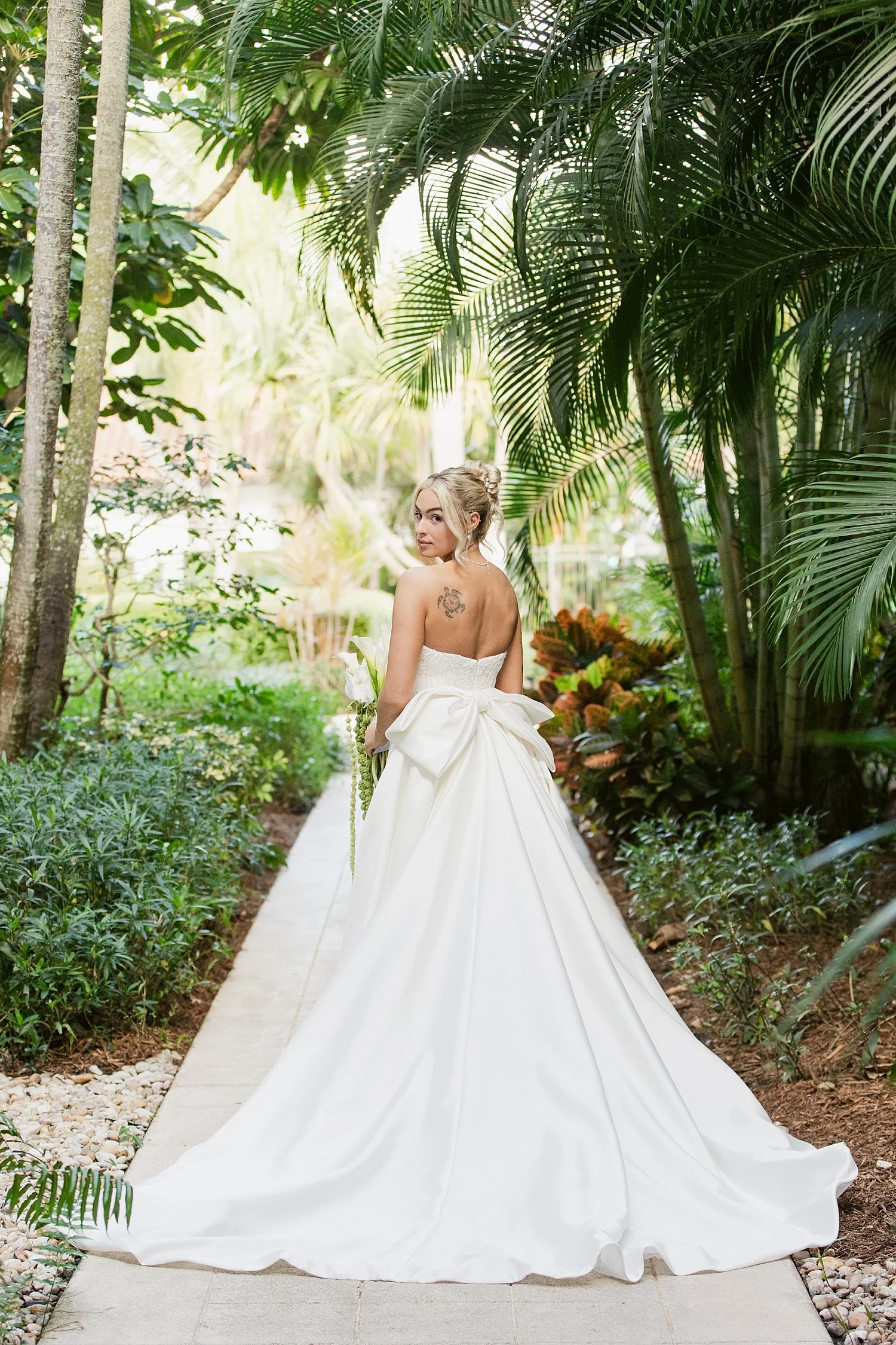  bride with long train under palm trees at PGA National Resort 