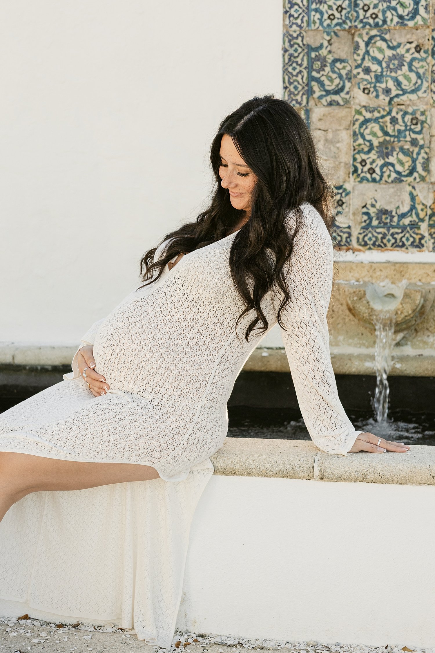  brunette expecting mama sits on fountain for Gasparilla Island Maternity Session 