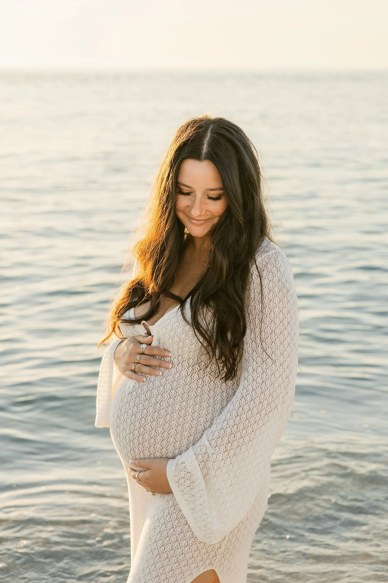  brunette mom stands next to ocean during golden hour by Taylor Shea Photo 