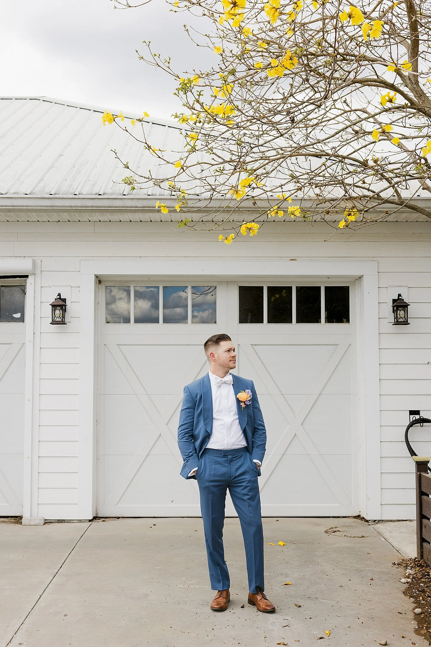  groom in navy suit in front of garage door by Taylor Shea Photo 
