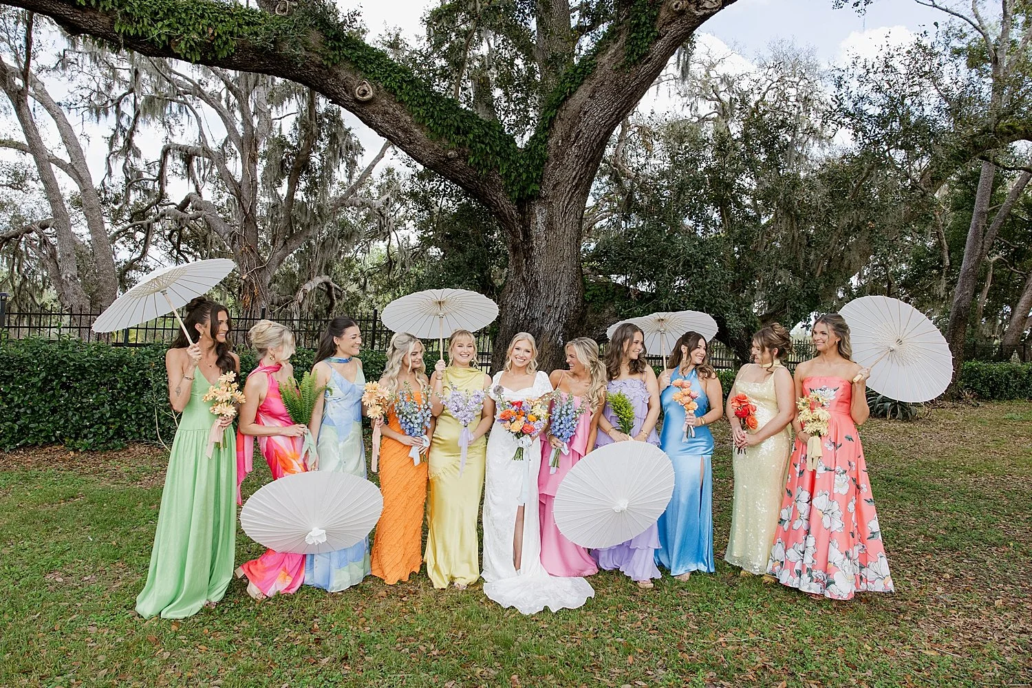  bridesmaids in mismatched colorful dresses and umbrellas by Florida wedding photographer 
