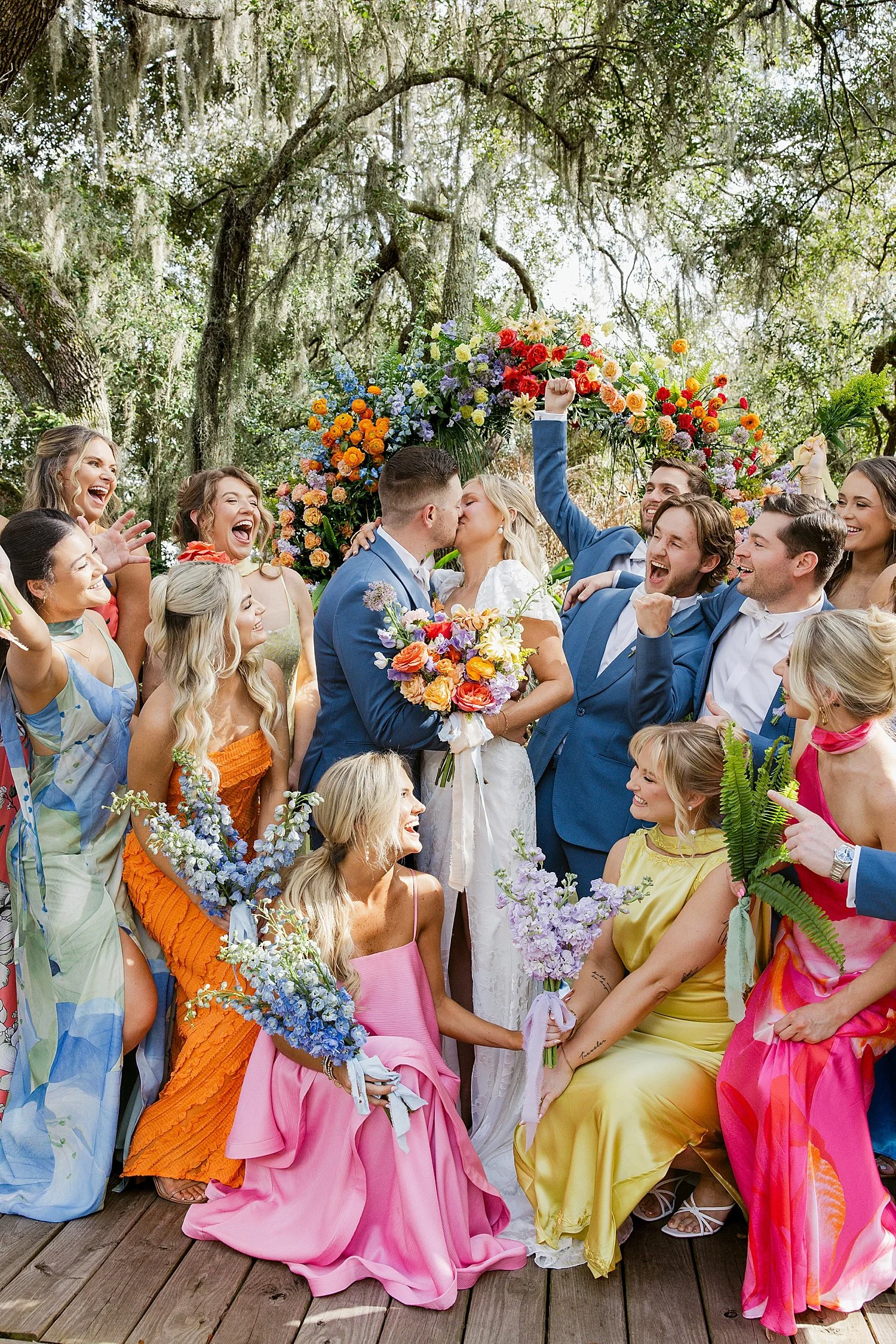  colorful wedding party surrounds newlyweds at alter at Mill Pond Estate 