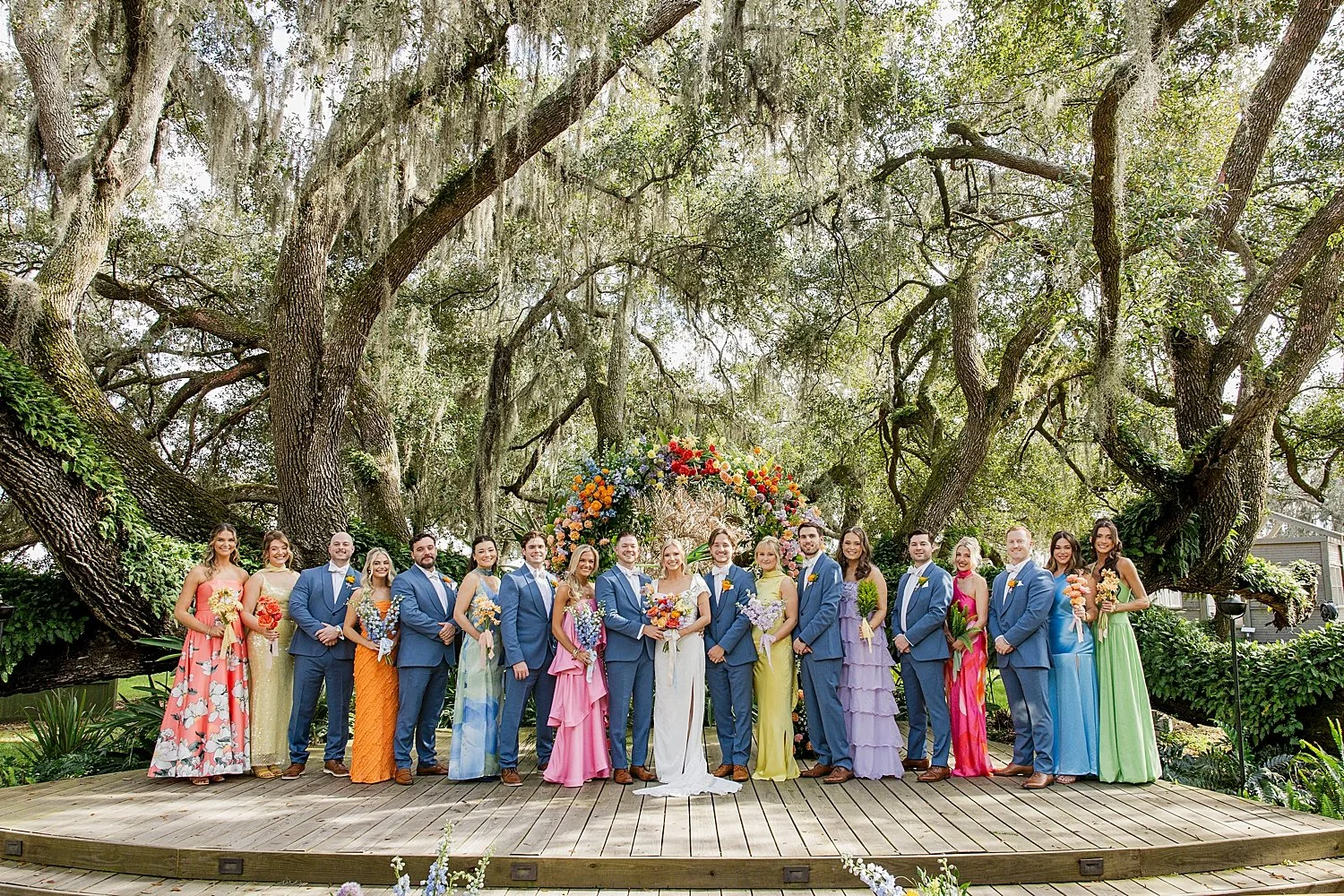  wedding party in bright loud colors on the lawn with couple by Florida wedding photographer 