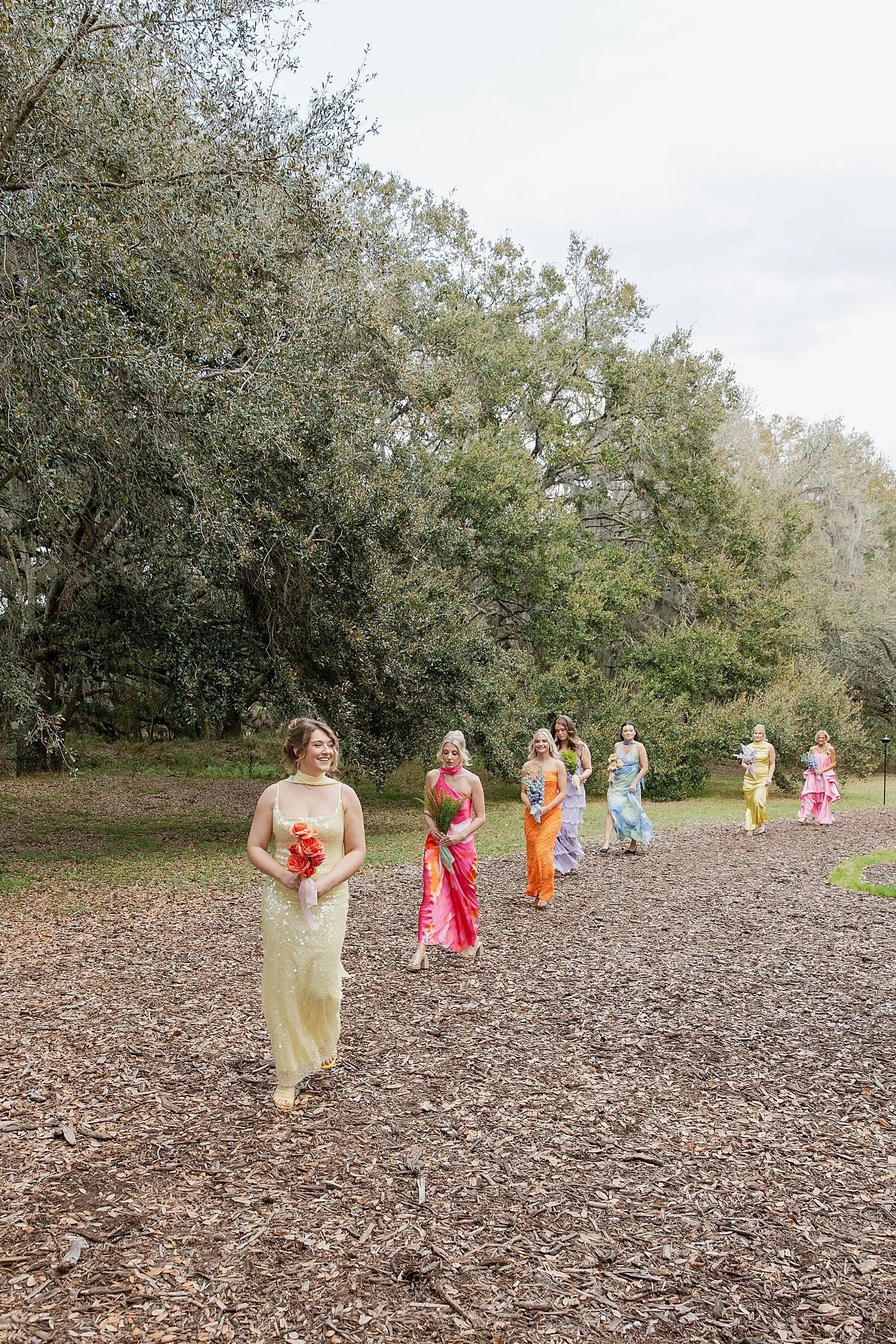  bridesmaids in colorful dresses walk to ceremony by Taylor Shea Photo 