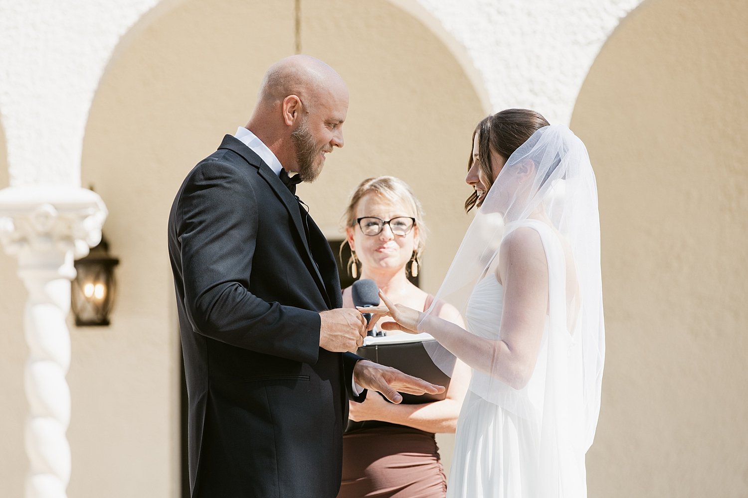  couple exchanges vows in front of officiant outside by Florida wedding photographer 