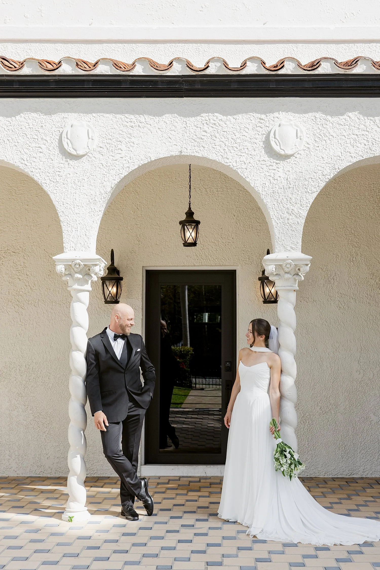  newlyweds stand on either side of arched walkway by Taylor Shea Photo 