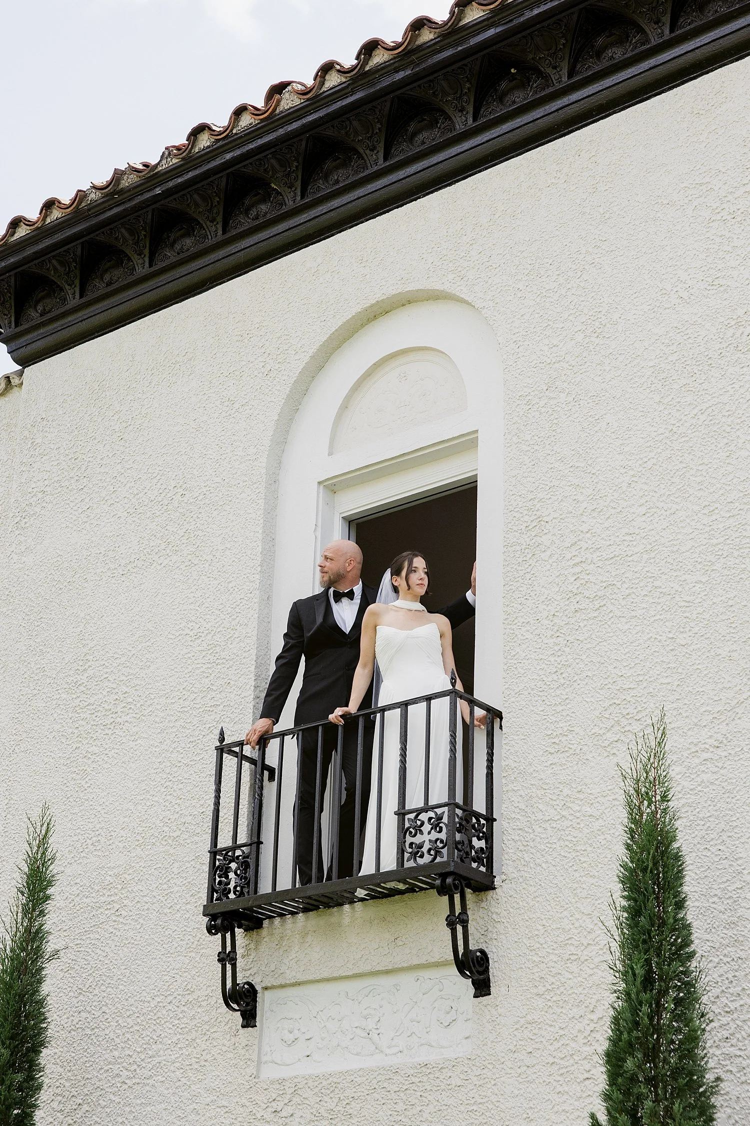  husband and wife stand on balcony for their ceremony + newlywed portraits 