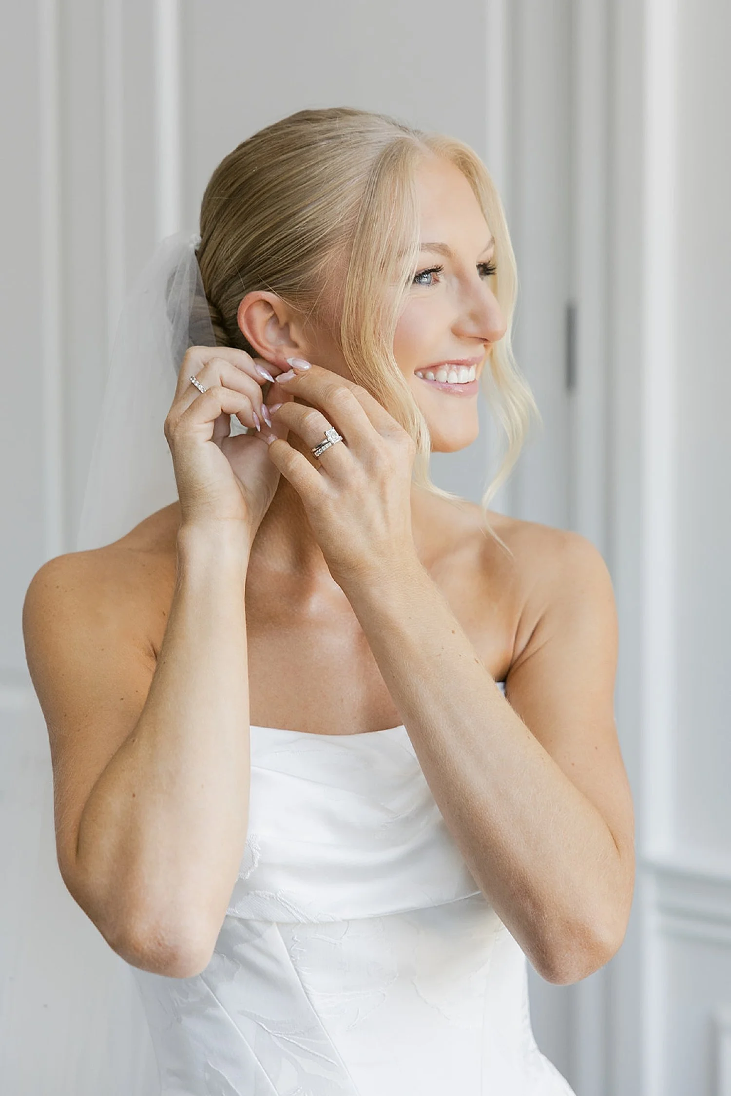  blonde woman fixes her earring in white dress at Hideaway Beach Club 