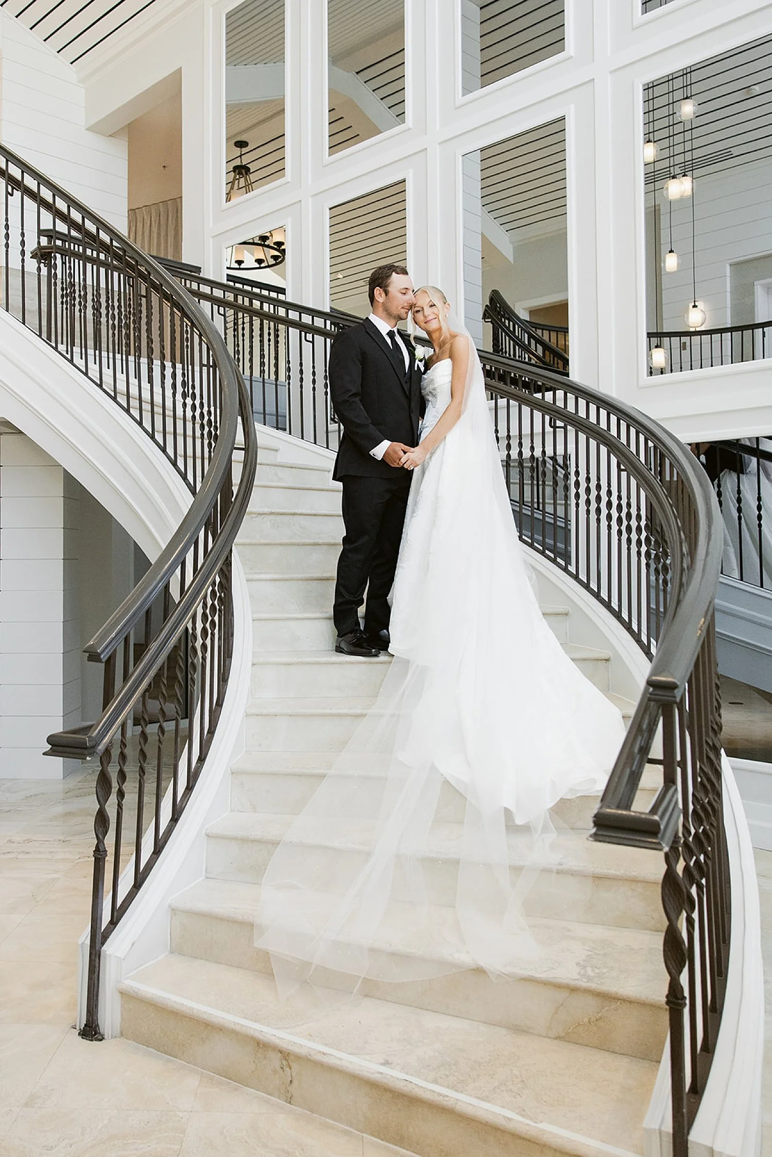  couple stand on grand, sweeping staircase by Florida wedding photographer 
