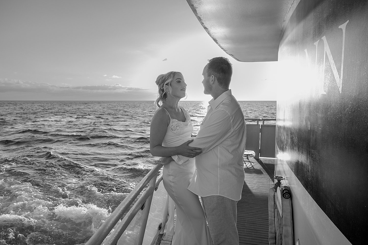 man and woman lean against the railing for wedding weekend on yacht 