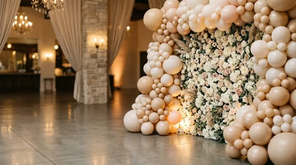 Champagne and blush balloon arch framing a floral photo wall as a memory anchor for memorable event design