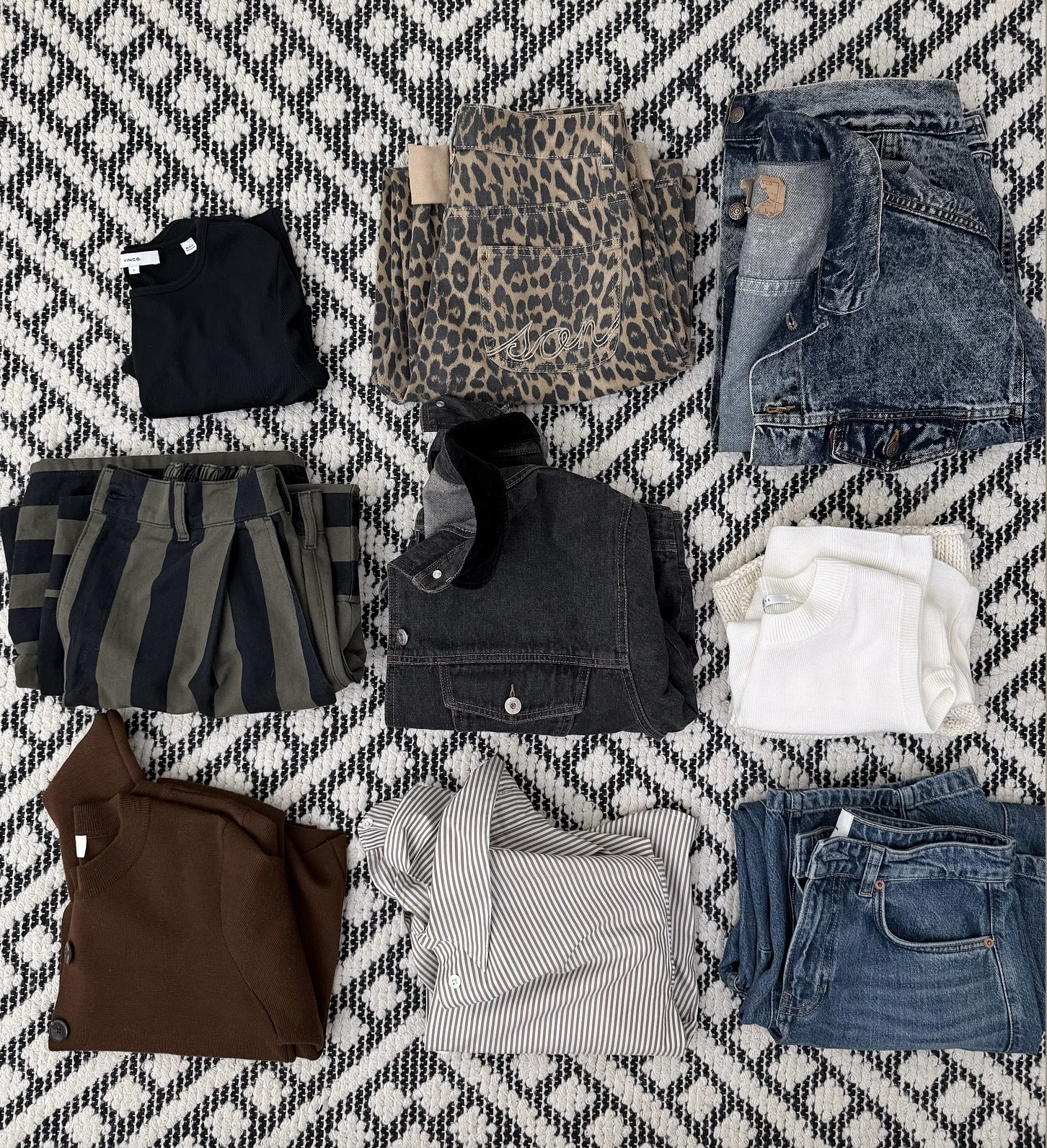 jeans, jackets, t shirt folded on a carpet