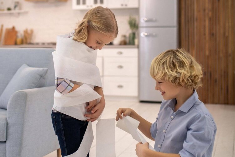 kids wrapping each other with toilet paper