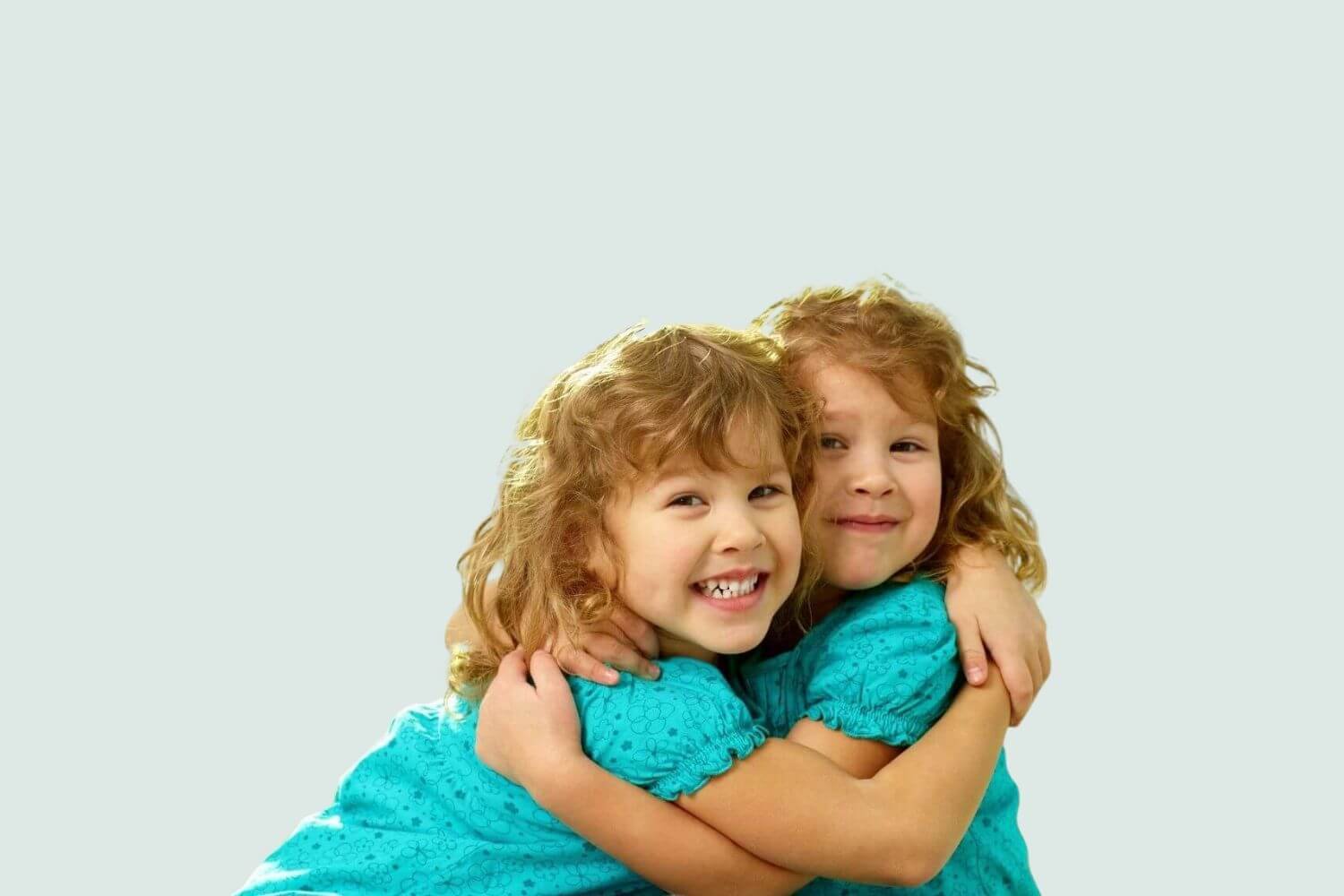 twin sisters wearing matching shirts hugging