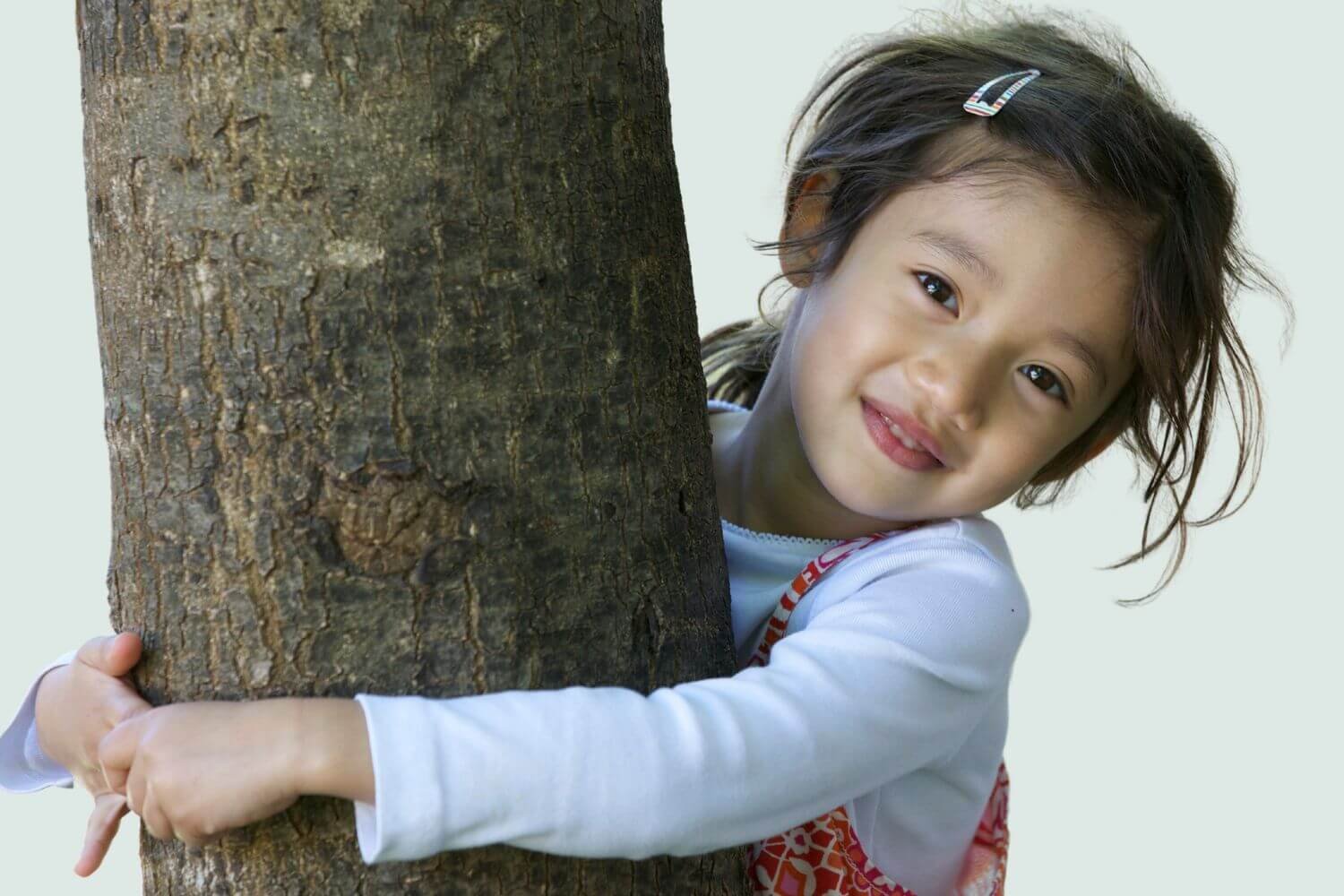 young girl hugging tree
