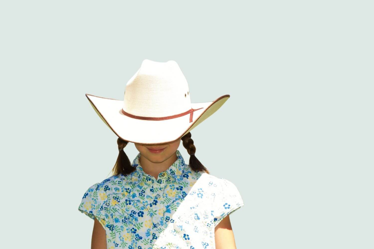 girl in pigtail braids wearing cowboy hat