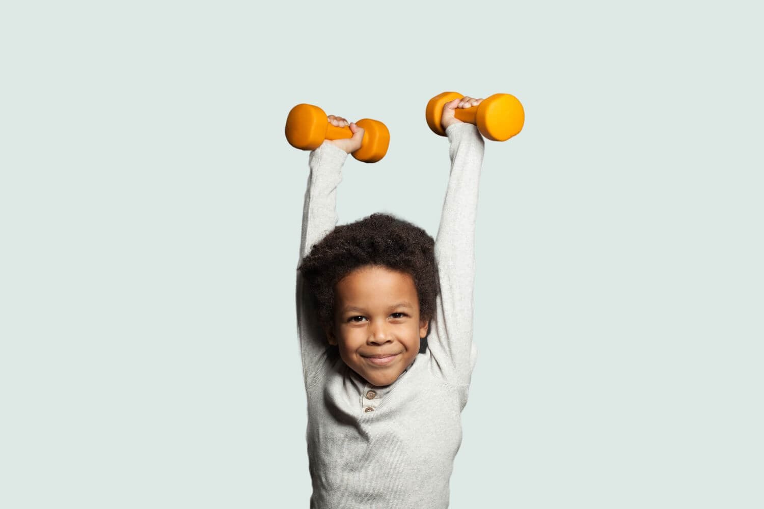 young boy holding up weights